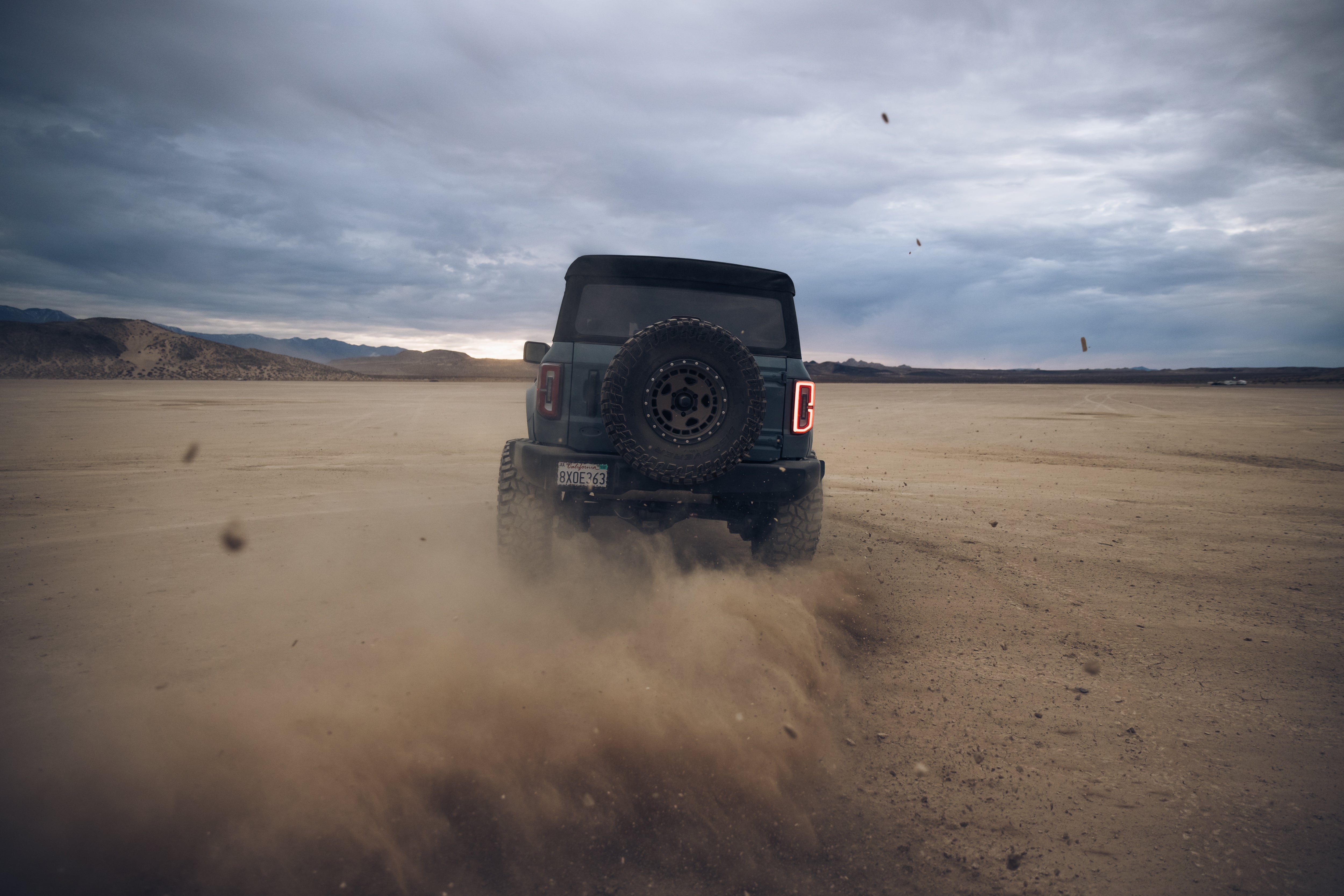 ADV Fiberglass 2021 Ford off-road vehicle kicking up dust in a desert landscape, showcasing rugged performance and style.