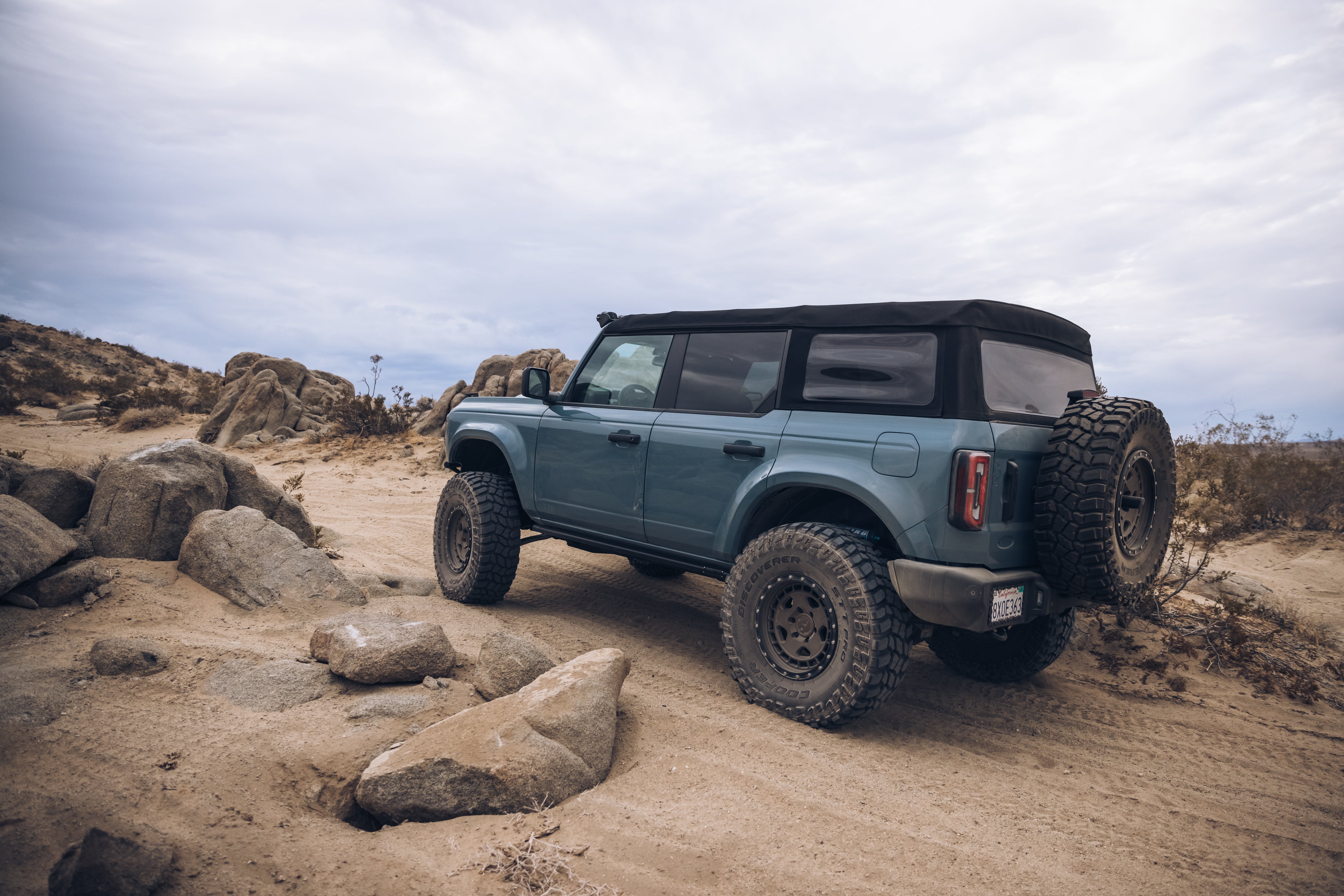 ADV Fiberglass 2021 Ford SUV parked on rugged terrain, showcasing offroad capabilities with large tires and a soft top.