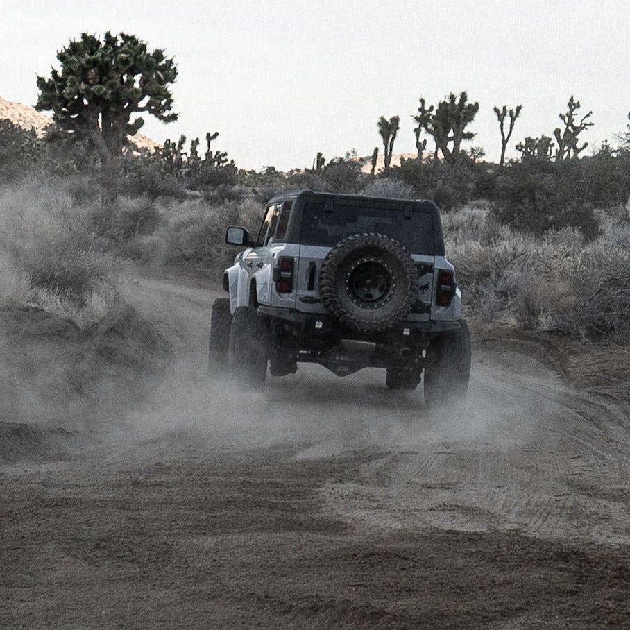 2022-2025 Ford Bronco Raptor fenders enhancing off-road performance on a dusty trail. Durable and stylish design for adventure.