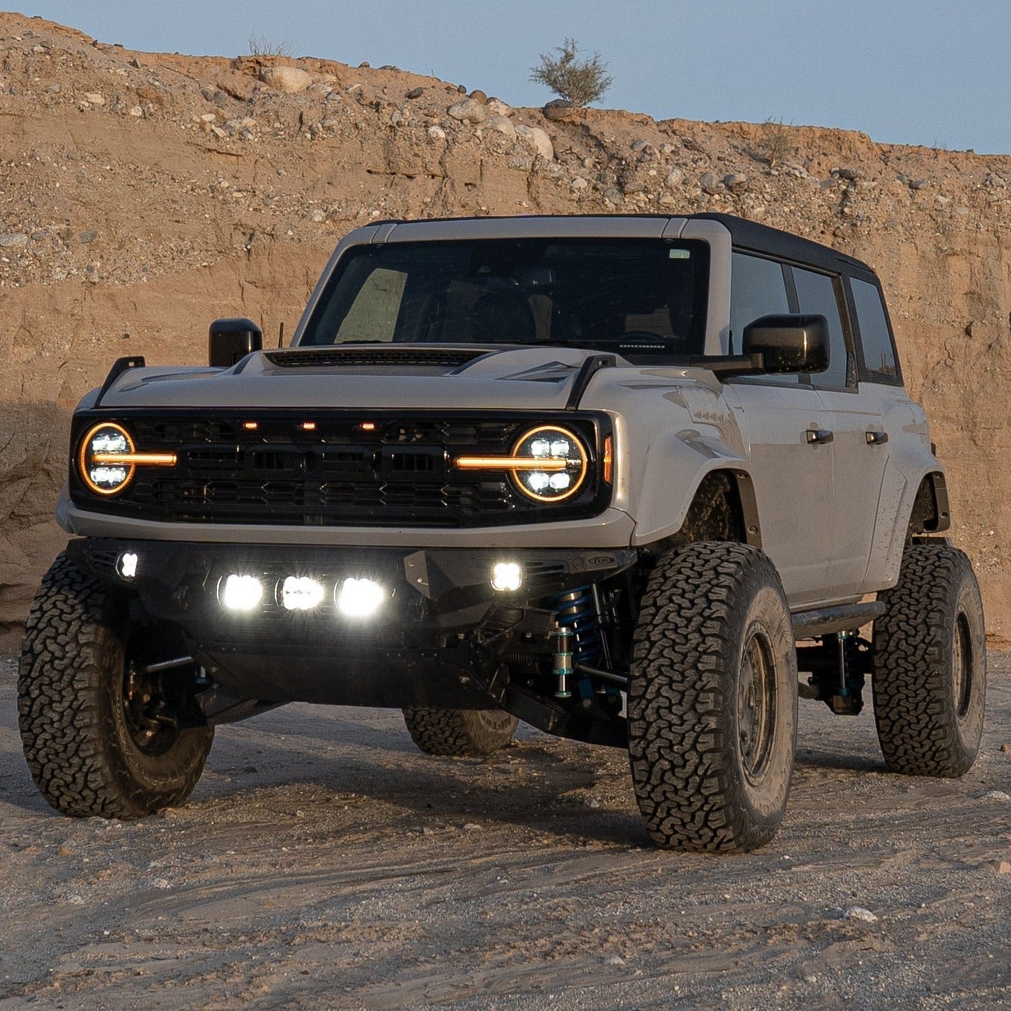 2022-2025 Ford Bronco Raptor with custom fenders, showcasing offroad capabilities and rugged design in a desert setting.