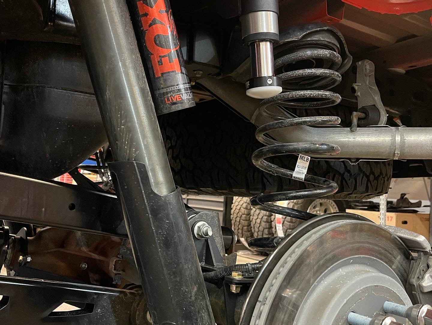 2021-2024 Ford Raptor rear bump stop kit installed, showcasing suspension components and coil spring detail.