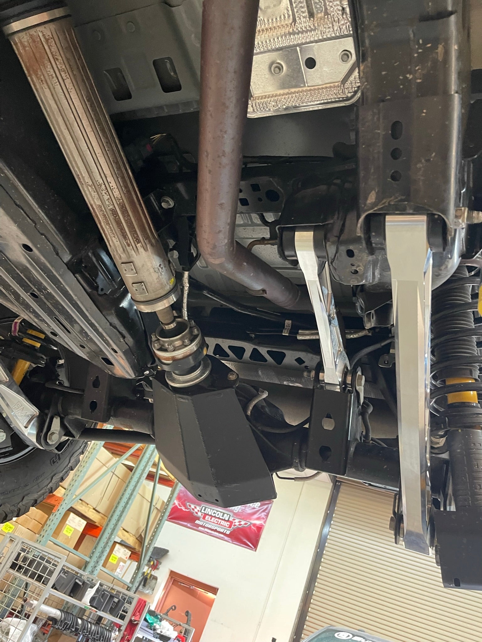 Billet aluminum rear suspension arms installed on a Bronco, showcasing the undercarriage and exhaust components.