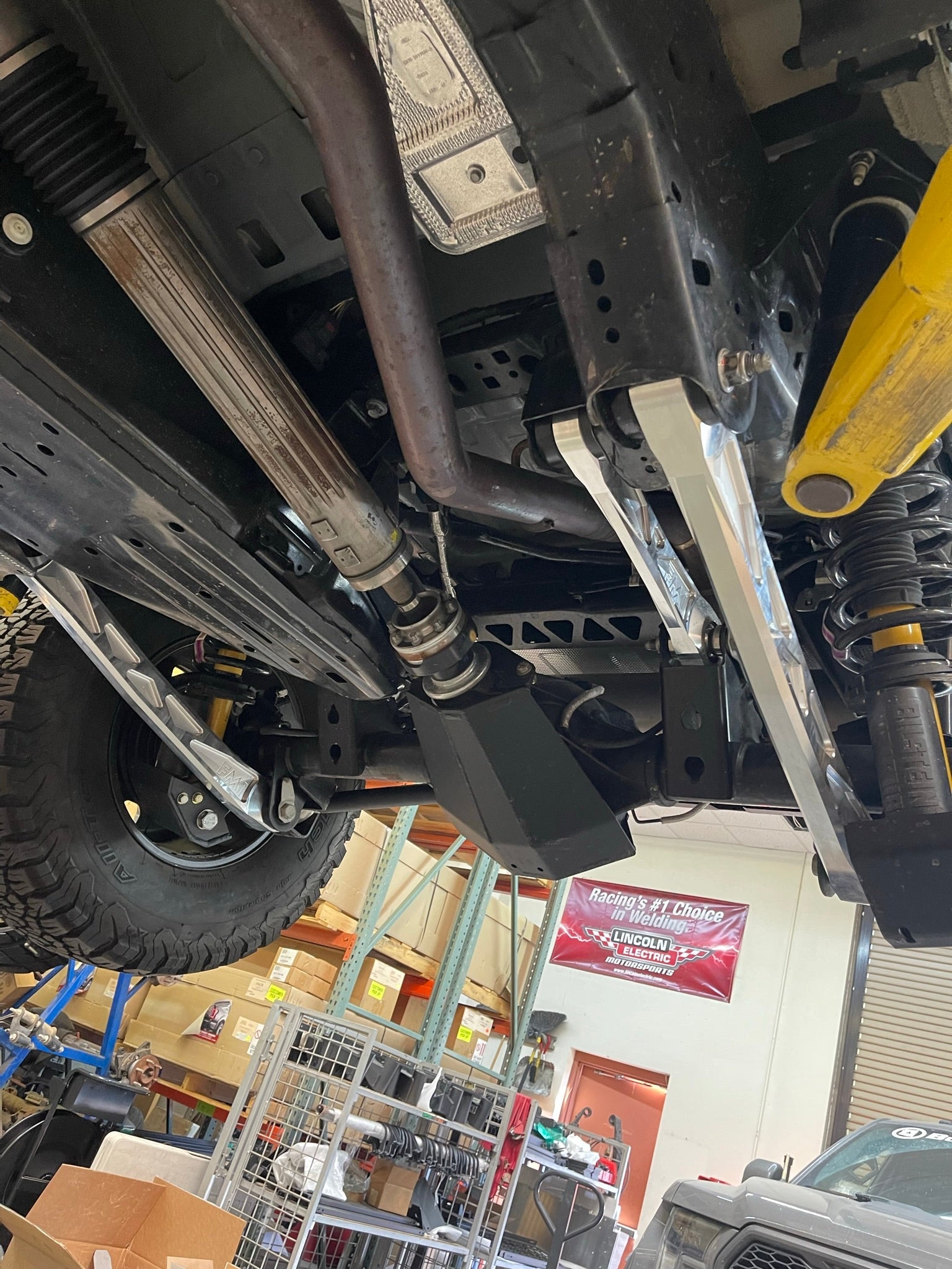 Billet aluminum rear suspension arms installed on a Bronco, showcasing the undercarriage and suspension components.