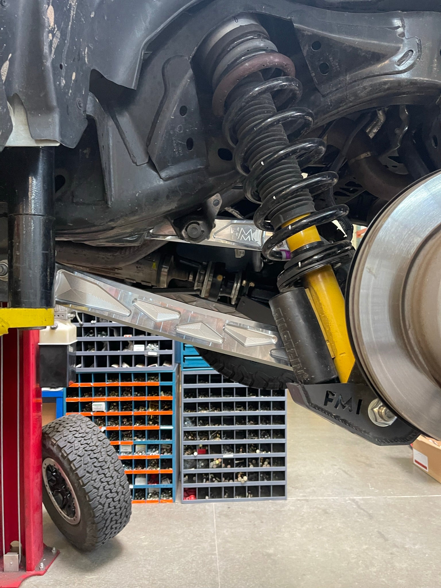 Bronco rear suspension kit featuring billet aluminum rear arms, showcasing coil springs and shock absorber installation.
