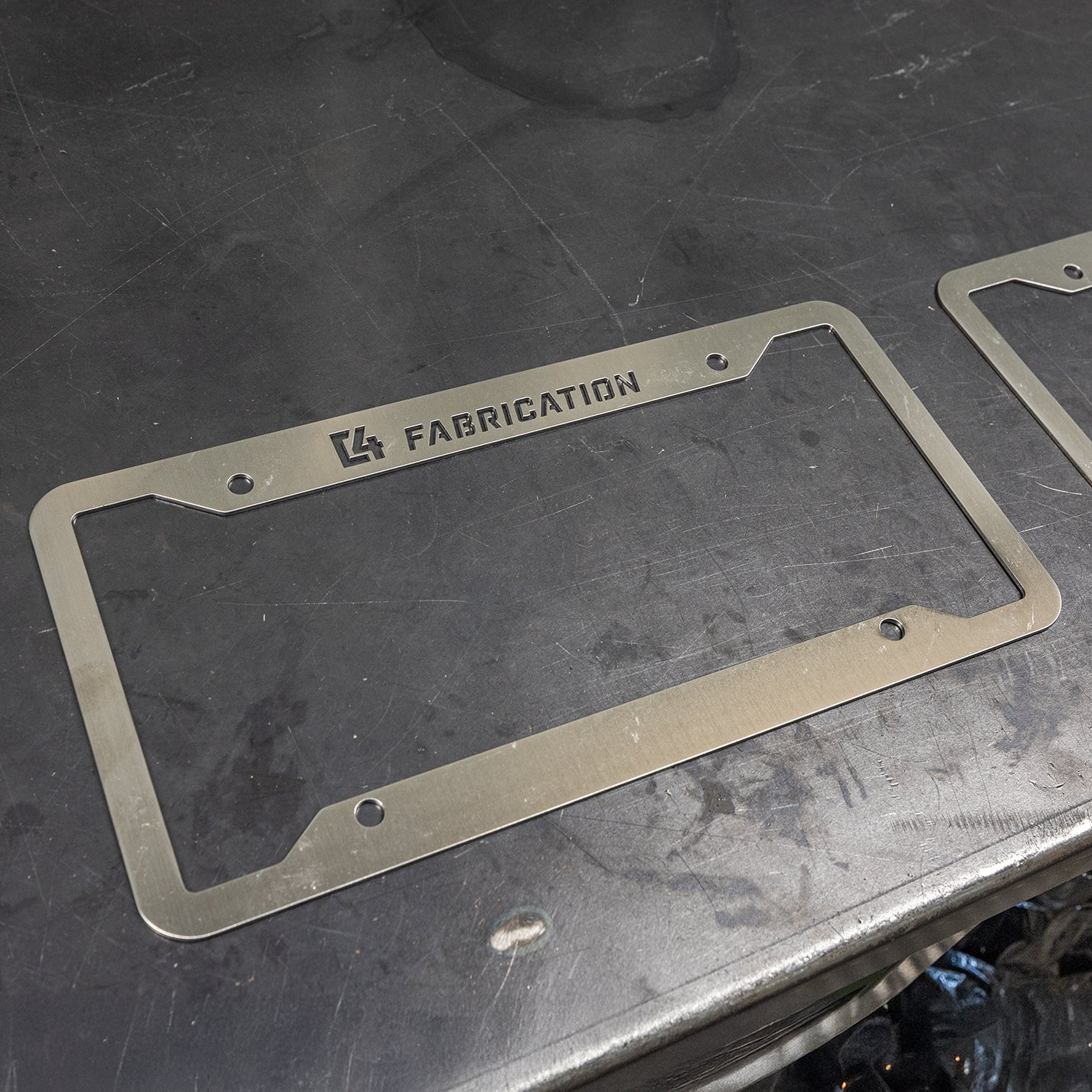 C4 License Plate Frame made of durable metal, featuring a sleek design with the C4 Fabrication logo.