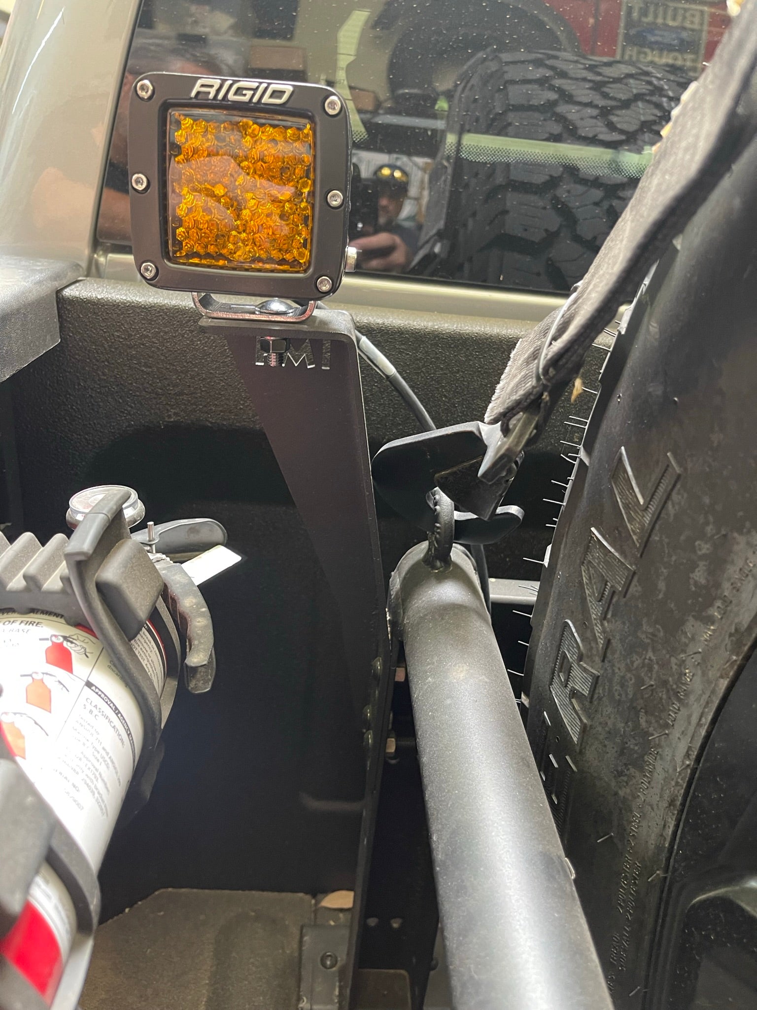 Bed Organizer Chase Rack Add On Light Mount Kit installed in a truck bed, featuring a light mounted on a bracket beside a fire extinguisher.