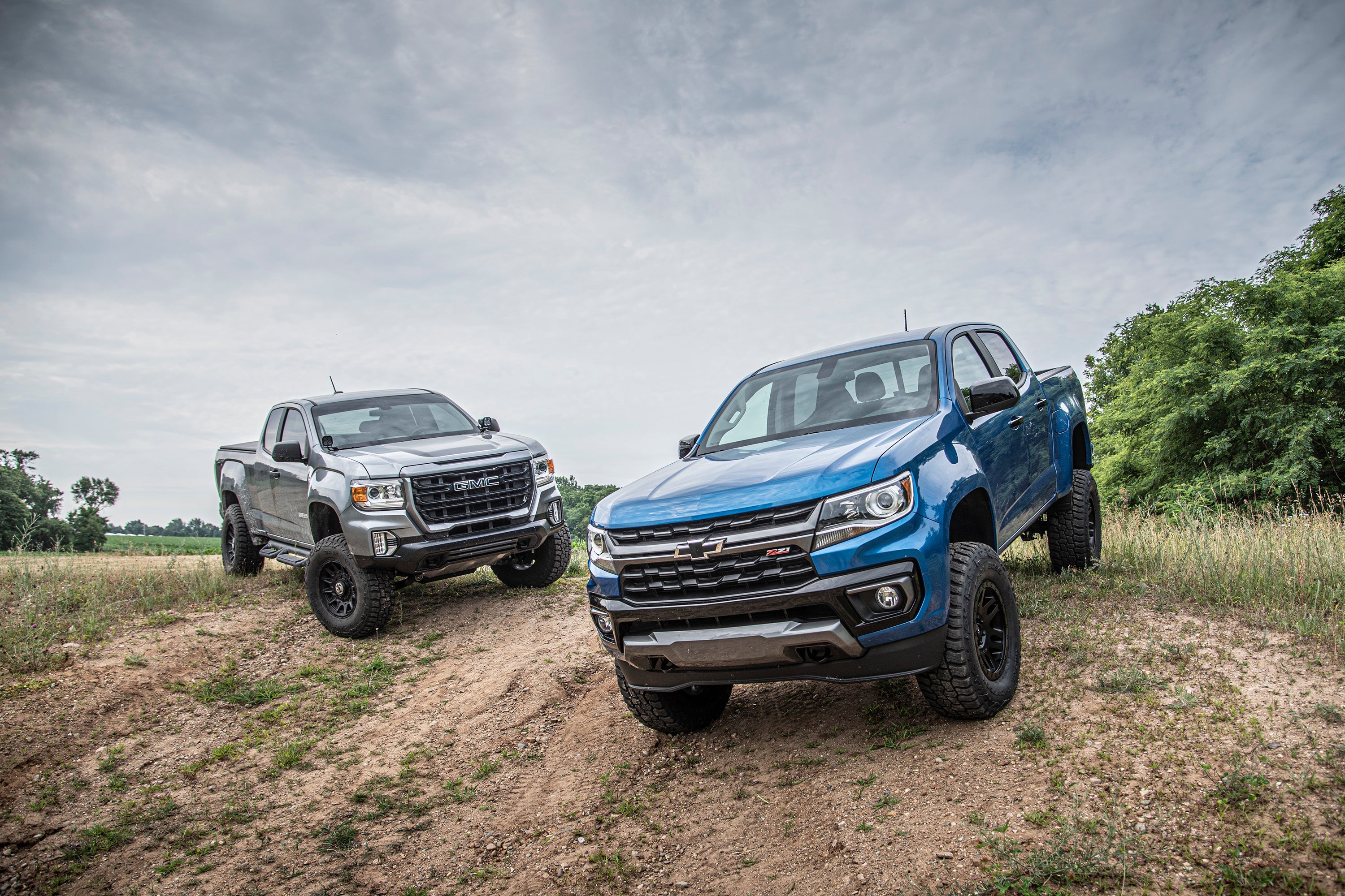 5.5 inch lift kit with FOX 2.5 coil-over installed on Chevy Colorado and GMC Canyon trucks in a rugged outdoor setting.