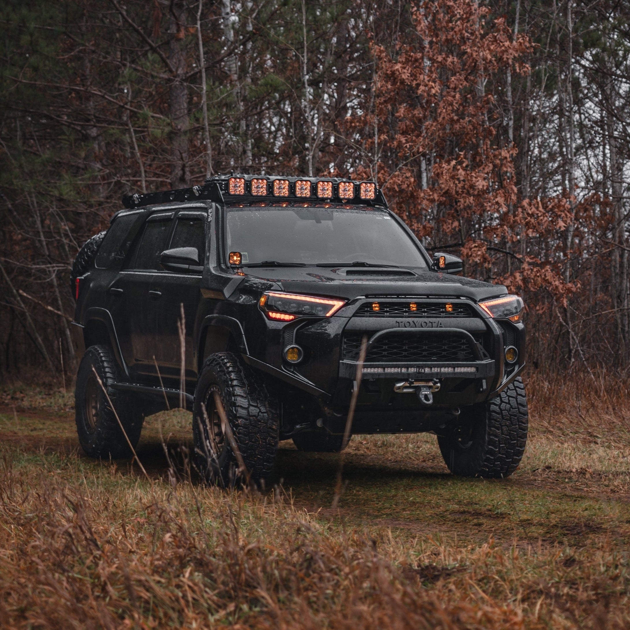 4Runner Lo-Pro Winch Bumper for 5th Gen models (2014-2024) on a rugged black SUV in a forest setting.