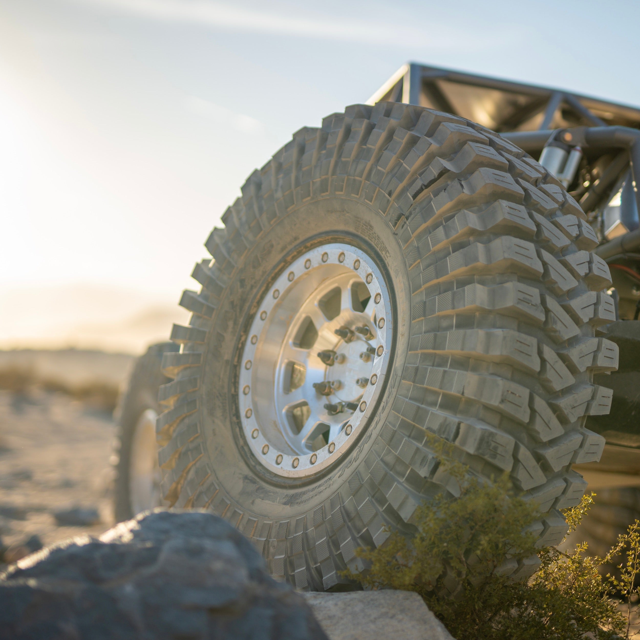 Aluminum beadlock ring mounted on an off-road tire, showcasing rugged tread and durable design for enhanced performance.