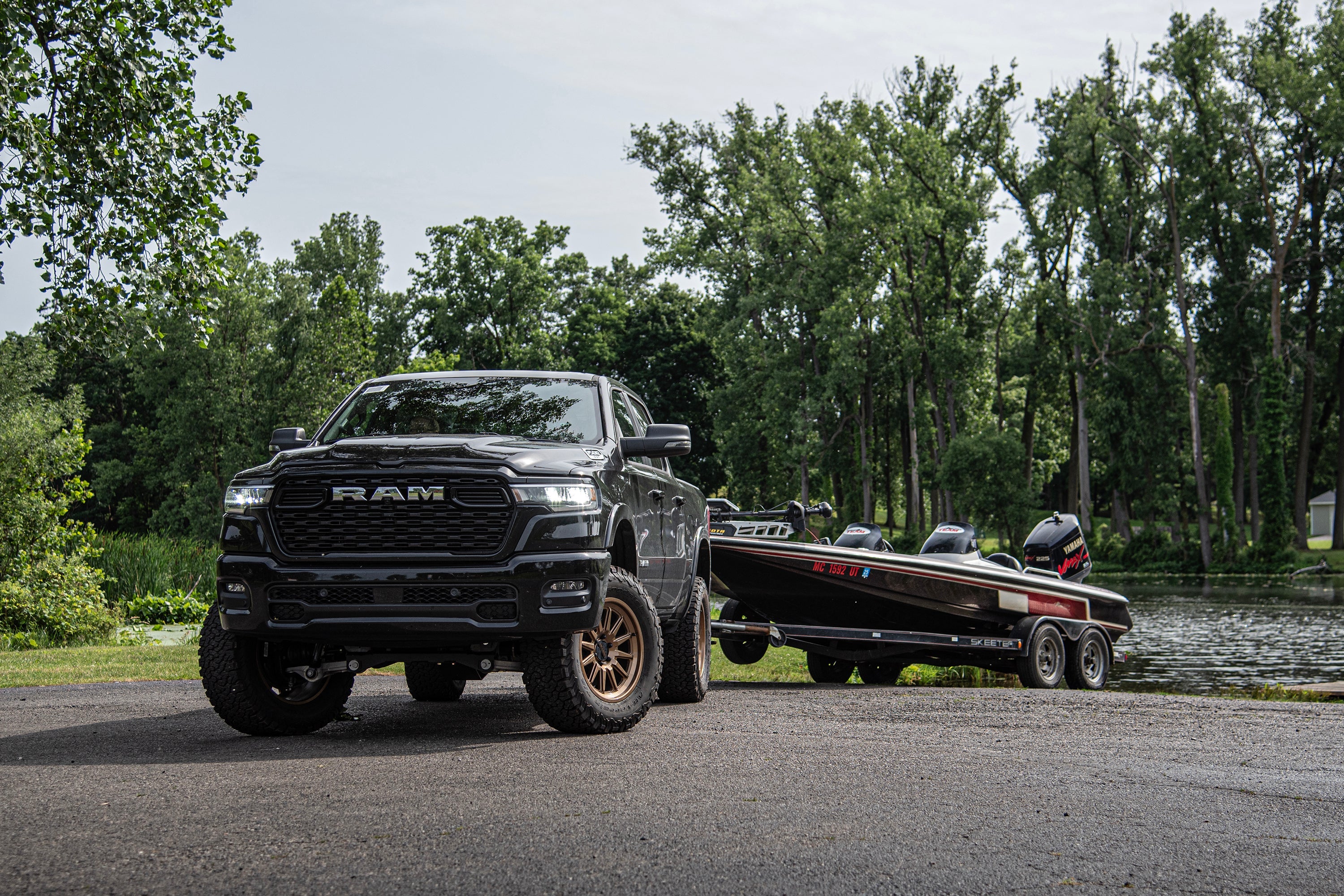 3-inch lift kit with FOX 2.5 coil-over on a Ram 1500 Rebel parked by a lake with a boat trailer nearby.