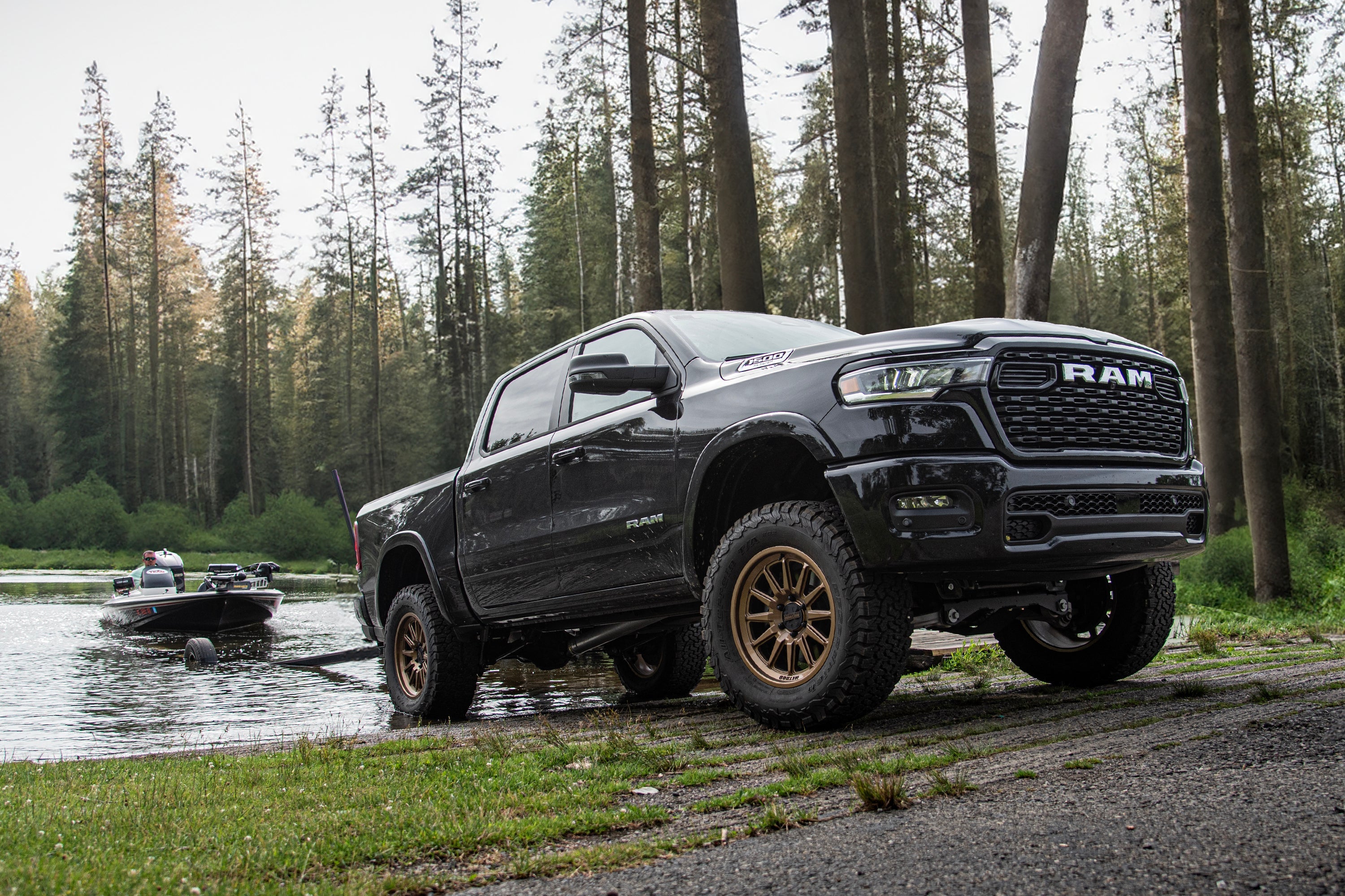 3-inch lift kit with FOX 2.5 Performance Elite coil-over installed on a Ram 1500 Rebel parked near a lake with a boat.