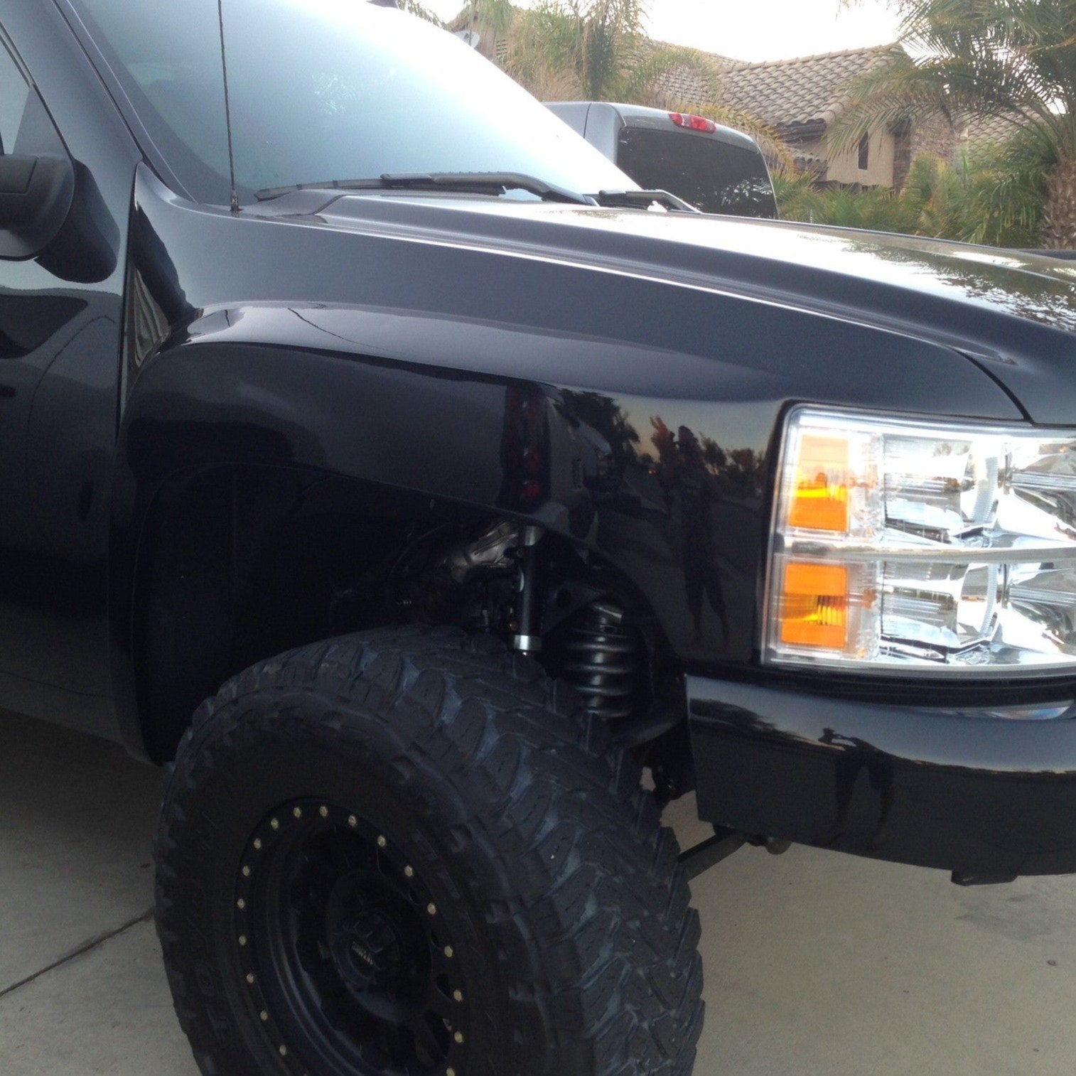 2007-2013 Chevrolet Silverado fender showcasing a sleek black finish and rugged off-road tire setup.
