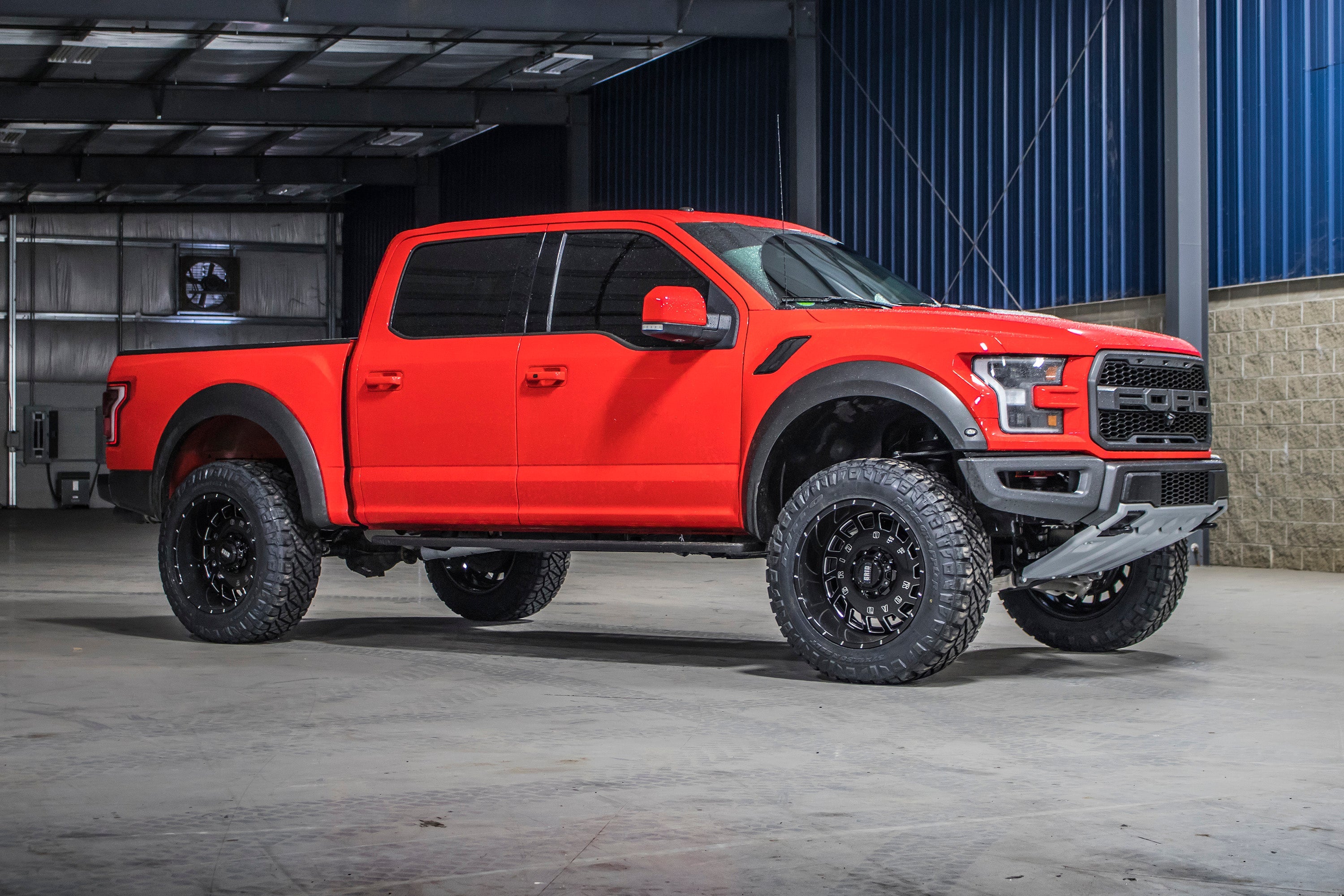 4-inch lift kit installed on a red Ford F150 Raptor (2019-2020) 4WD, showcasing enhanced off-road capabilities.