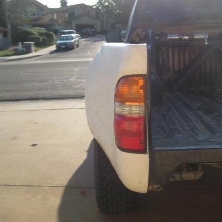1995-2004 Toyota Tacoma bedsides showcasing a white truck's rear view with a visible tail light and truck bed.