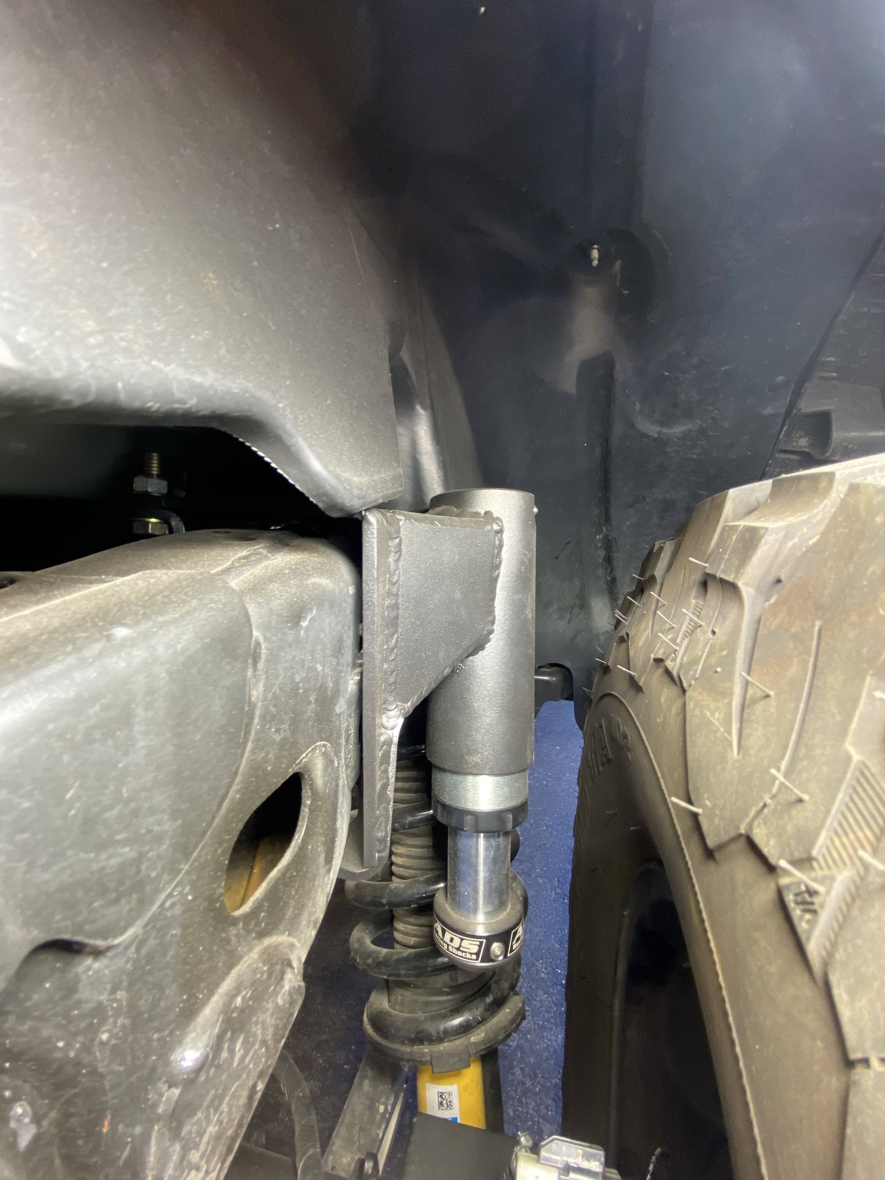 2021 and up Bronco rear hydraulic bump stop kit installed, showcasing its position near the suspension and tire.