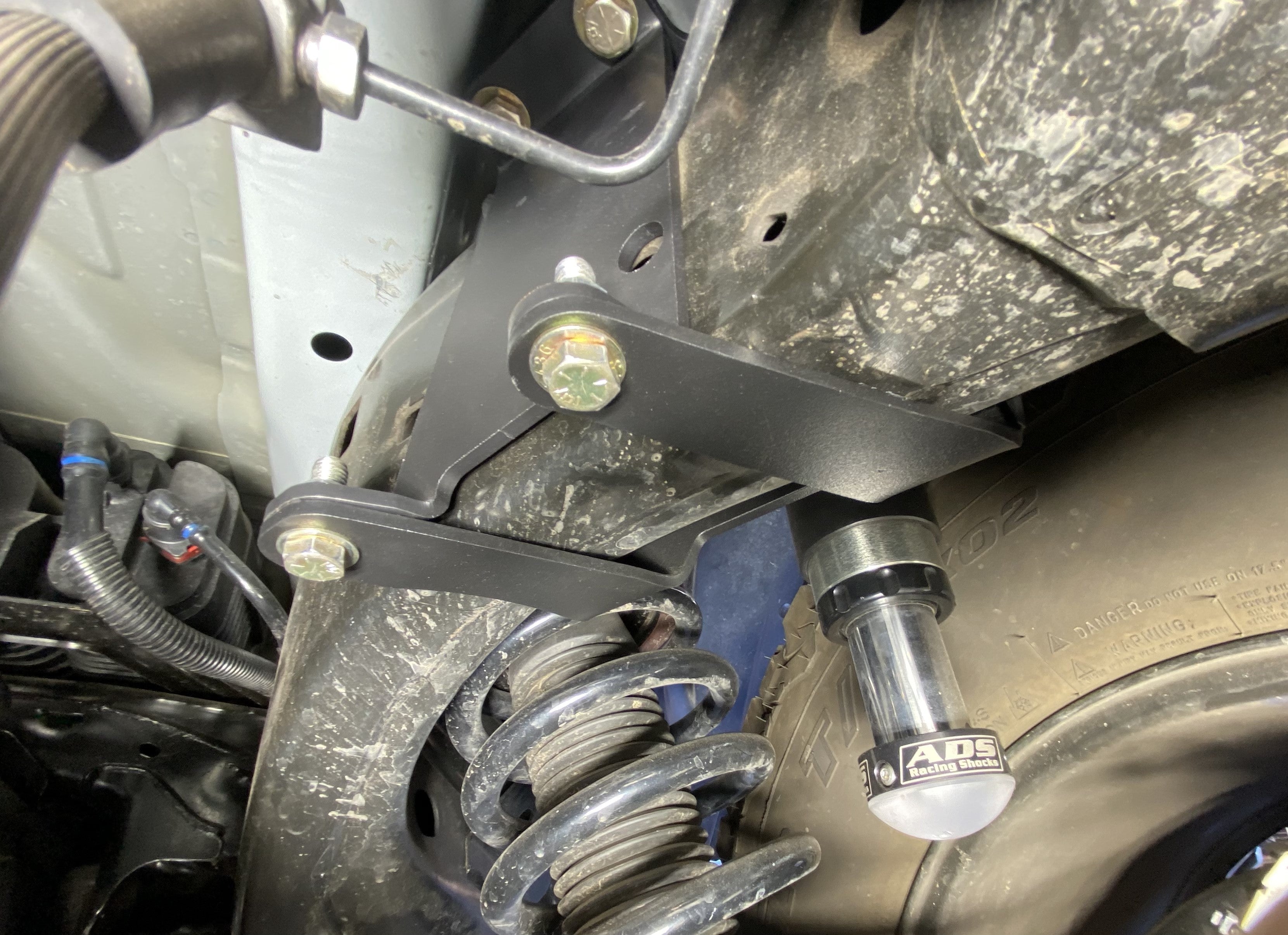 2021 and up Bronco rear hydraulic bump stop kit installed, showcasing mounting brackets and shock components.