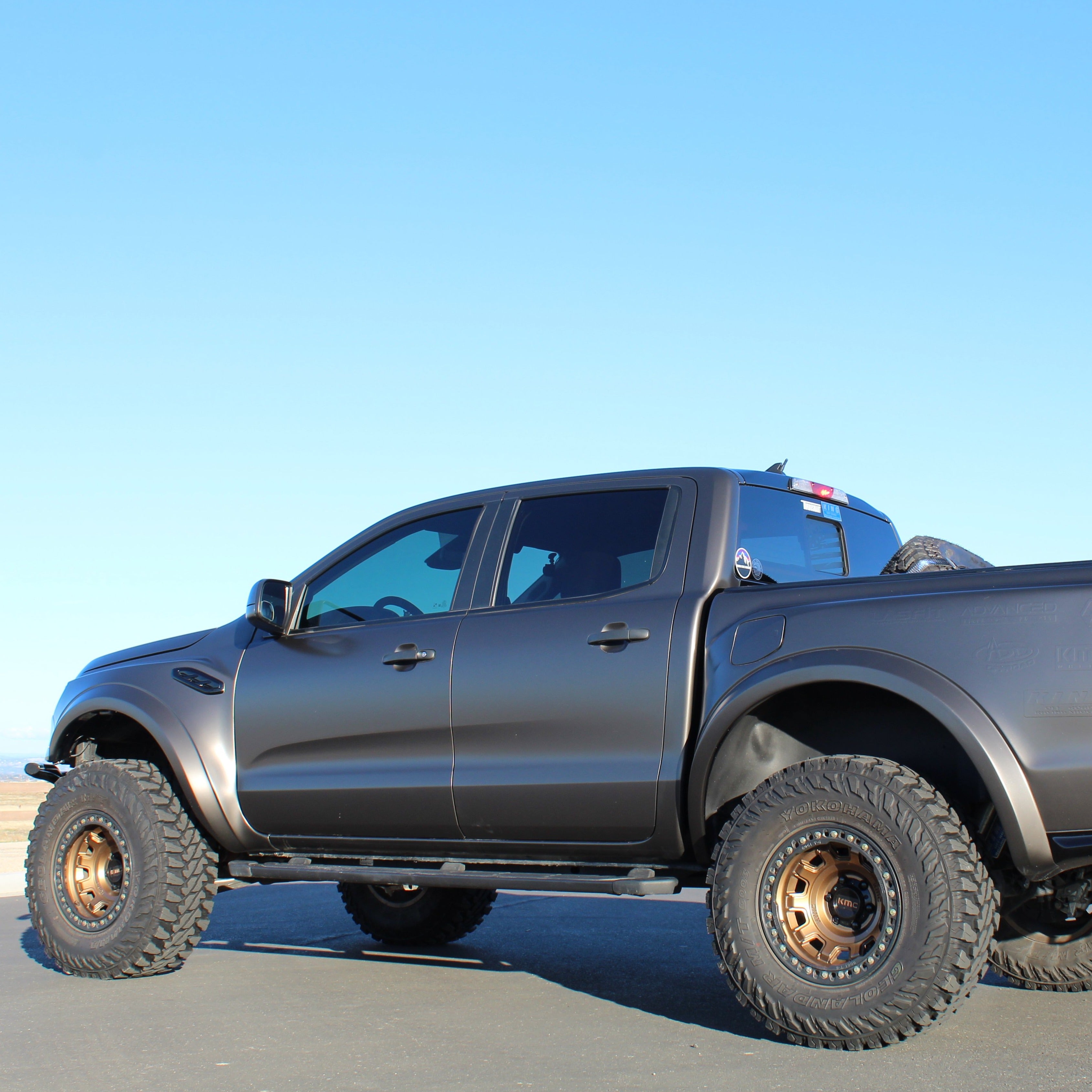 Matte black 2019-2023 Ford Ranger with oversized tires and fenders, showcasing an offroad-ready stance.