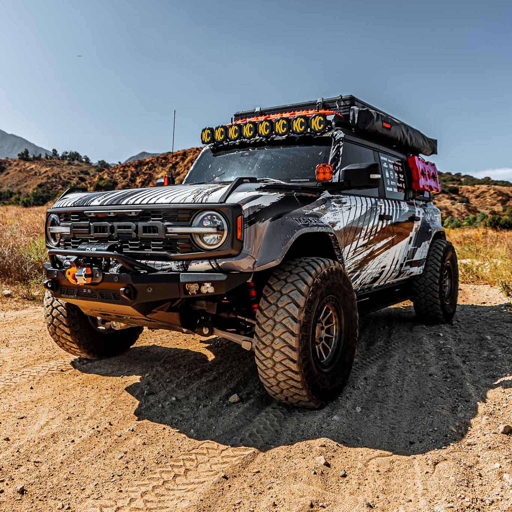 2022-2025 Ford Bronco Raptor with rear quarter kit, rugged off-road setup, equipped for adventure in a desert landscape.
