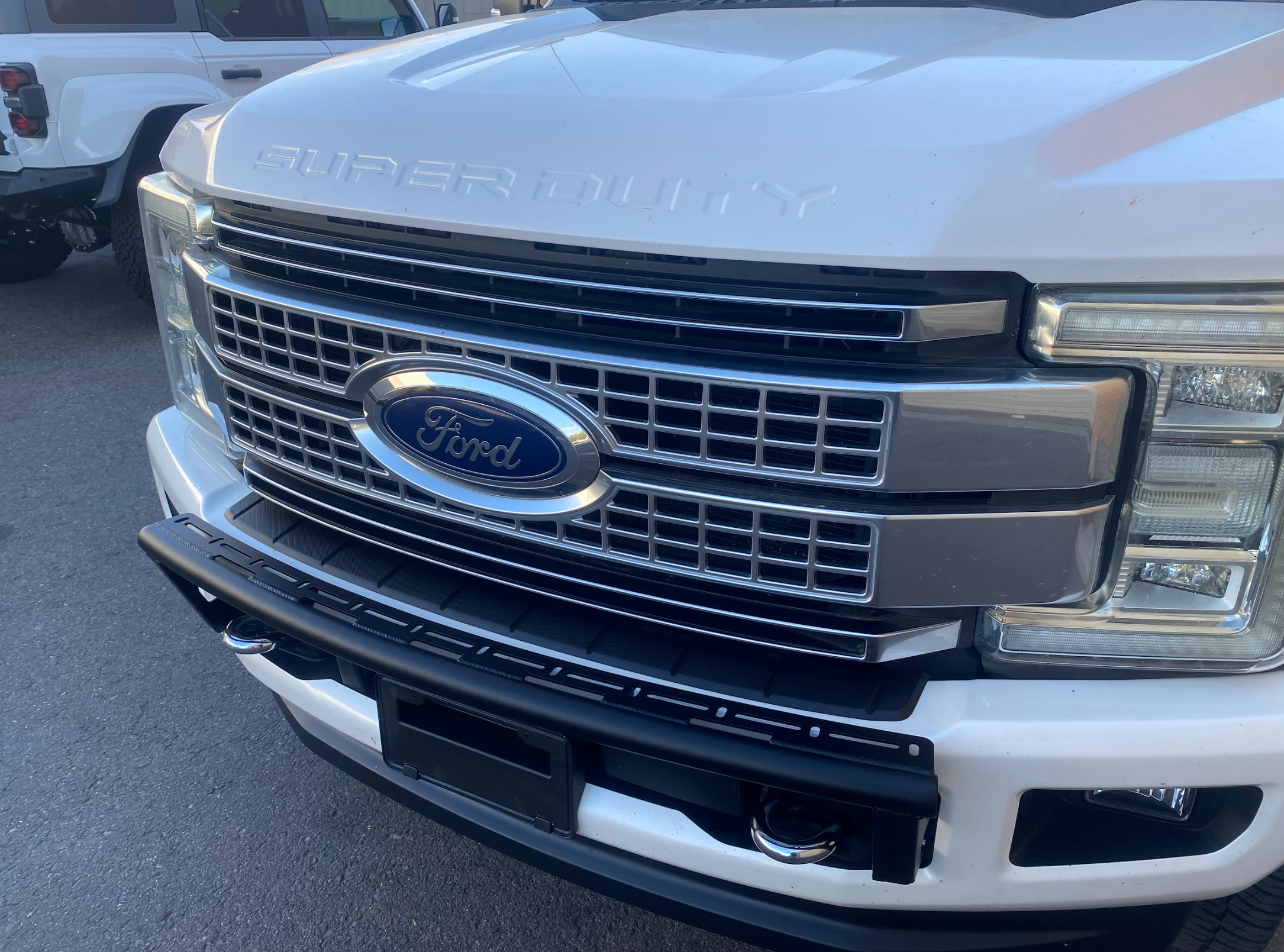 Front view of a 2017-2022 Ford F-250 Super Duty showcasing the Foutz Motorsports Front Light Mount Kit on a stock bumper.