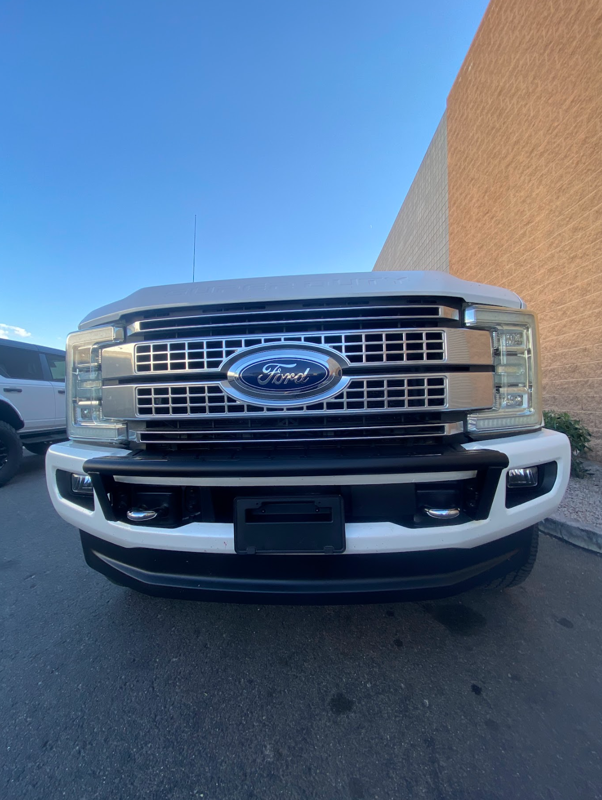 Front view of a 2017-2022 Ford F-250 Super Duty showcasing the Foutz Motorsports front light mount kit on a stock bumper.