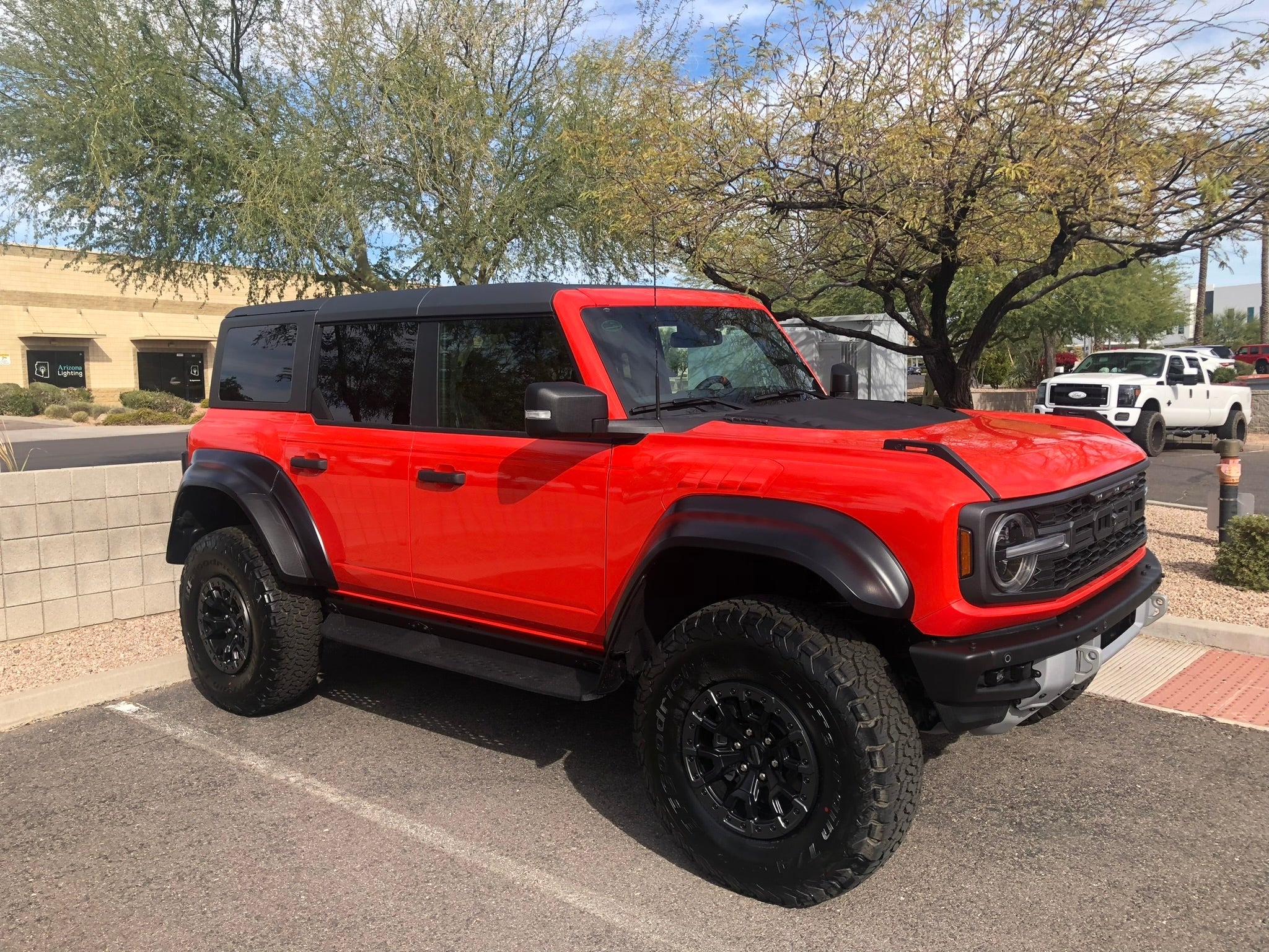 2022-UP Bronco Raptor front leveling kit installed on a red Bronco with offroad tires and a rugged design.