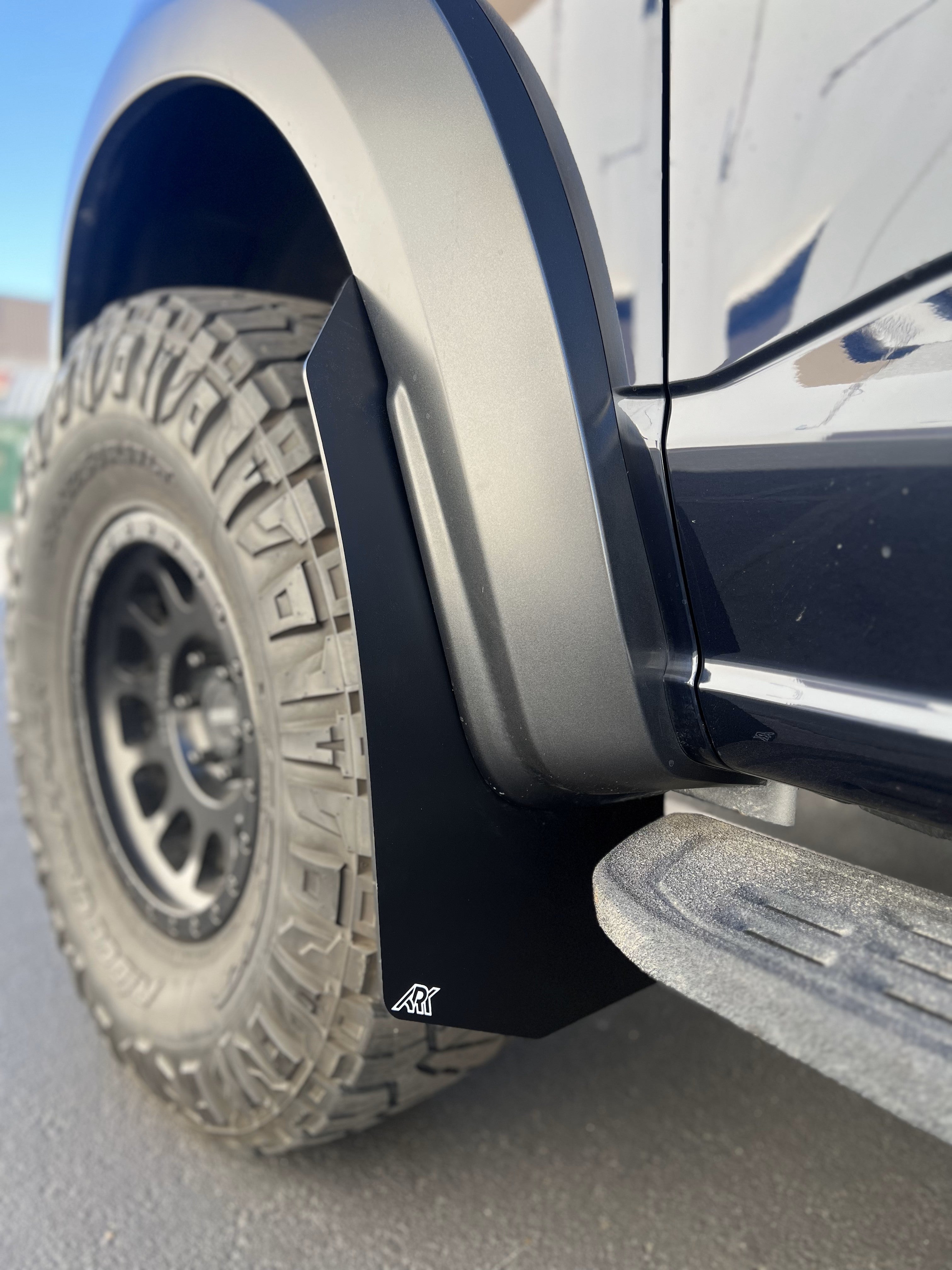 2021+ Ford Raptor mud flaps installed on a truck, showcasing rugged design and tire protection.