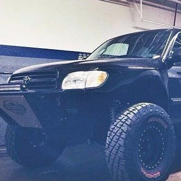 Black 2000-2006 Toyota Tundra with aftermarket fenders and off-road tires, showcasing a rugged, lifted appearance.