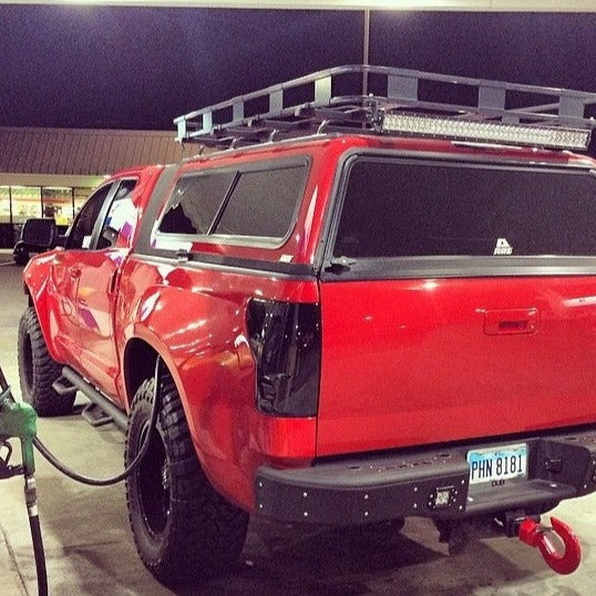 2007-2013 Toyota Tundra with custom bedsides at a gas station, showcasing a rugged offroad design and accessories.