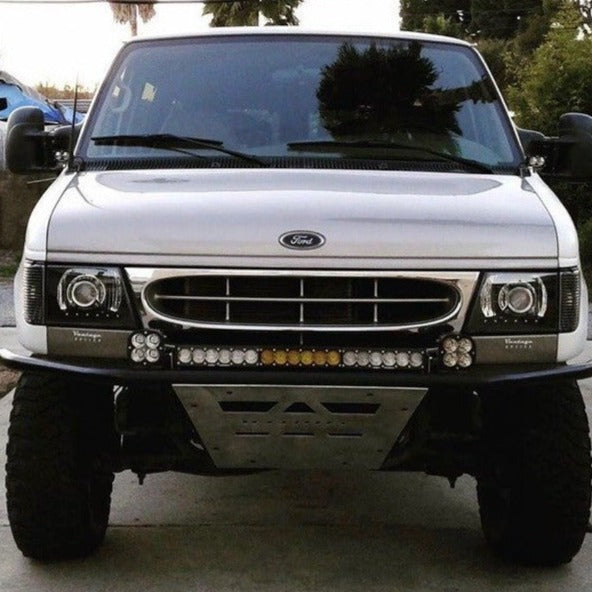 Front view of a modified Ford Econoline van showcasing aftermarket fenders and off-road lighting features.