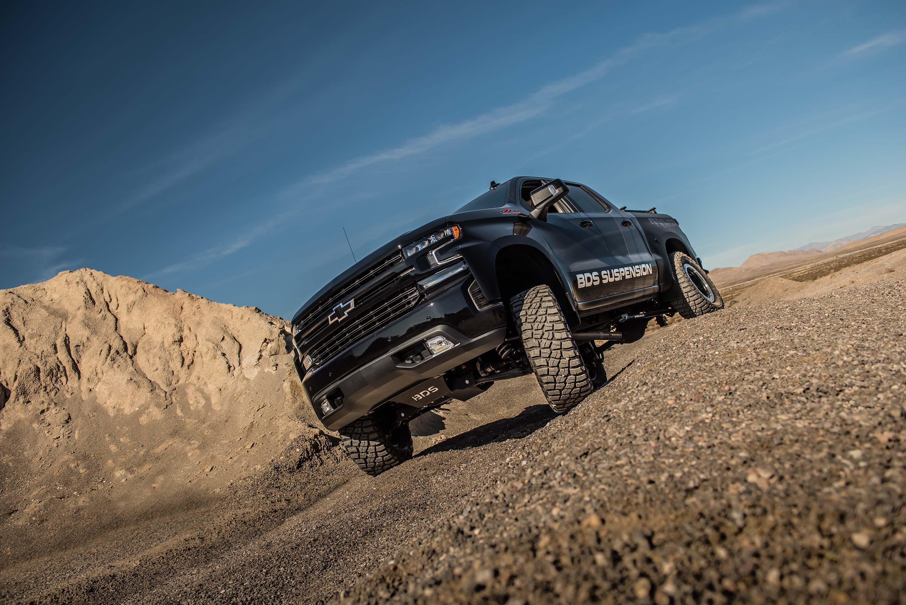 4-inch lift kit with FOX 2.5 coil-over installed on a Chevy Trail Boss, showcasing off-road capability in a rugged landscape.