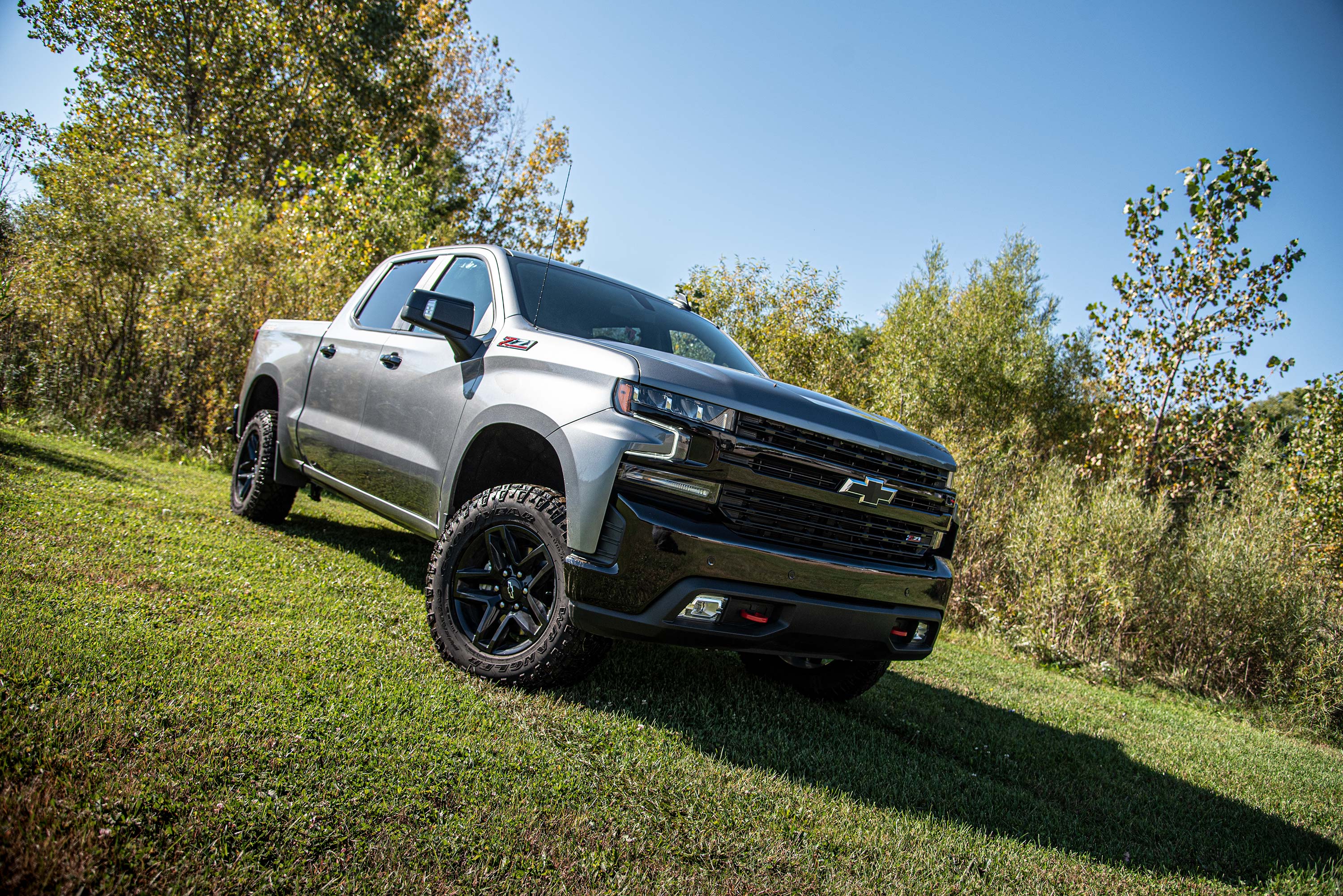 Chevy Silverado with a 2-inch leveling kit and FOX 2.5 coil-over suspension, showcasing an elevated stance in a natural setting.