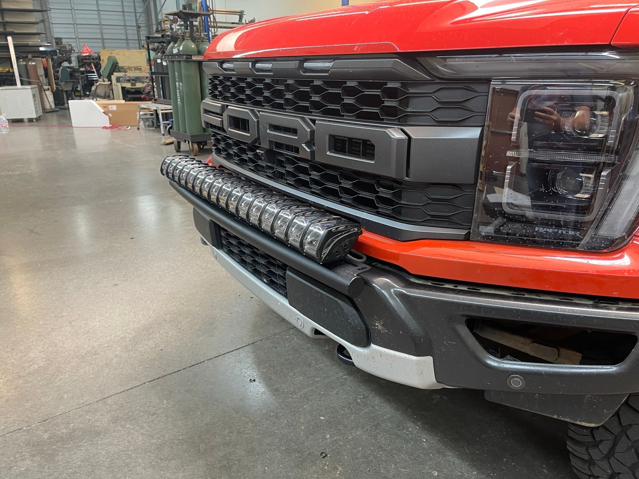2024 Raptor Front Light Mount Kit for modular bumpers, showcasing a mounted light bar on a red truck's front.