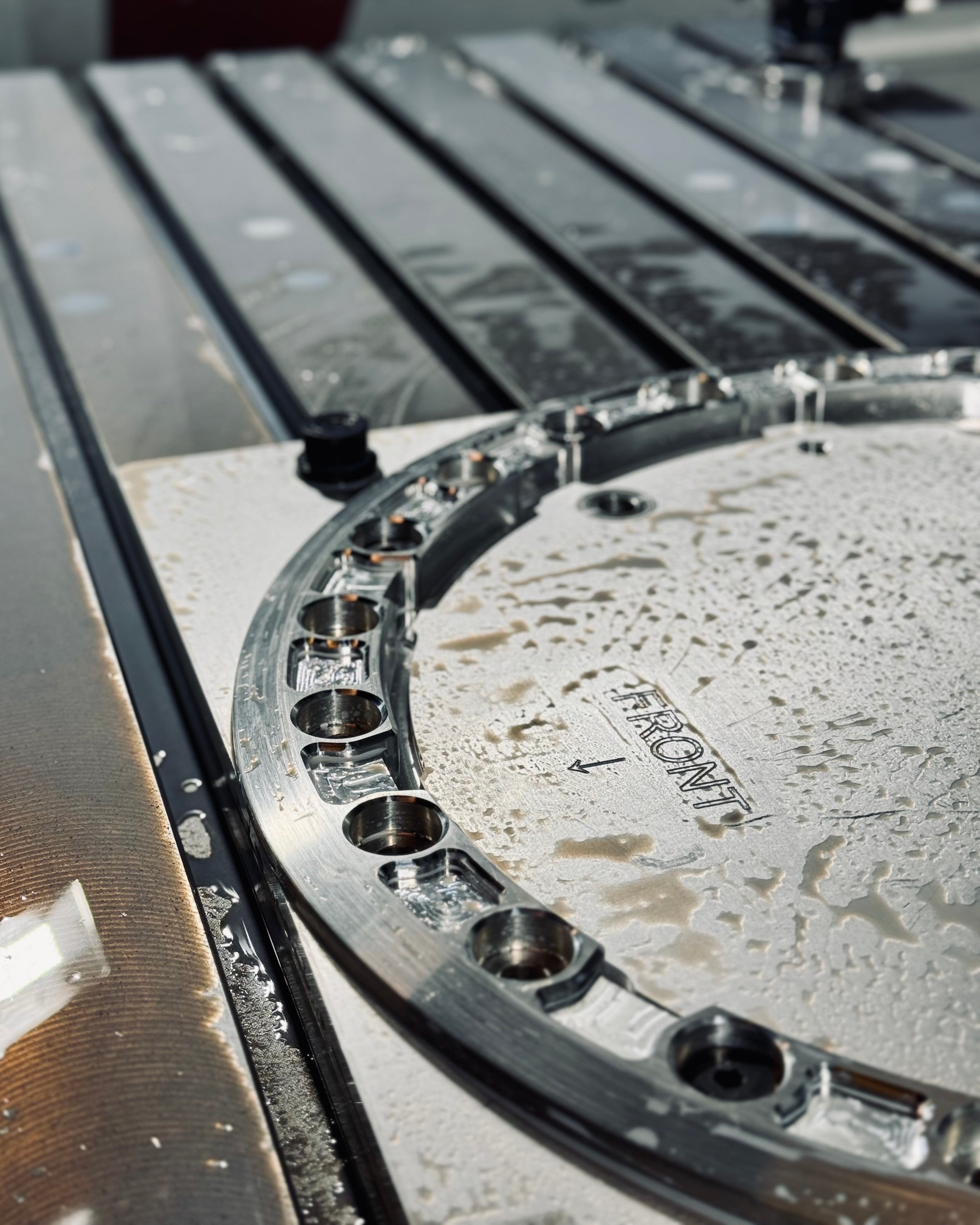 Aluminum beadlock ring on a machining surface, showcasing precision manufacturing and detailing for offroad applications.