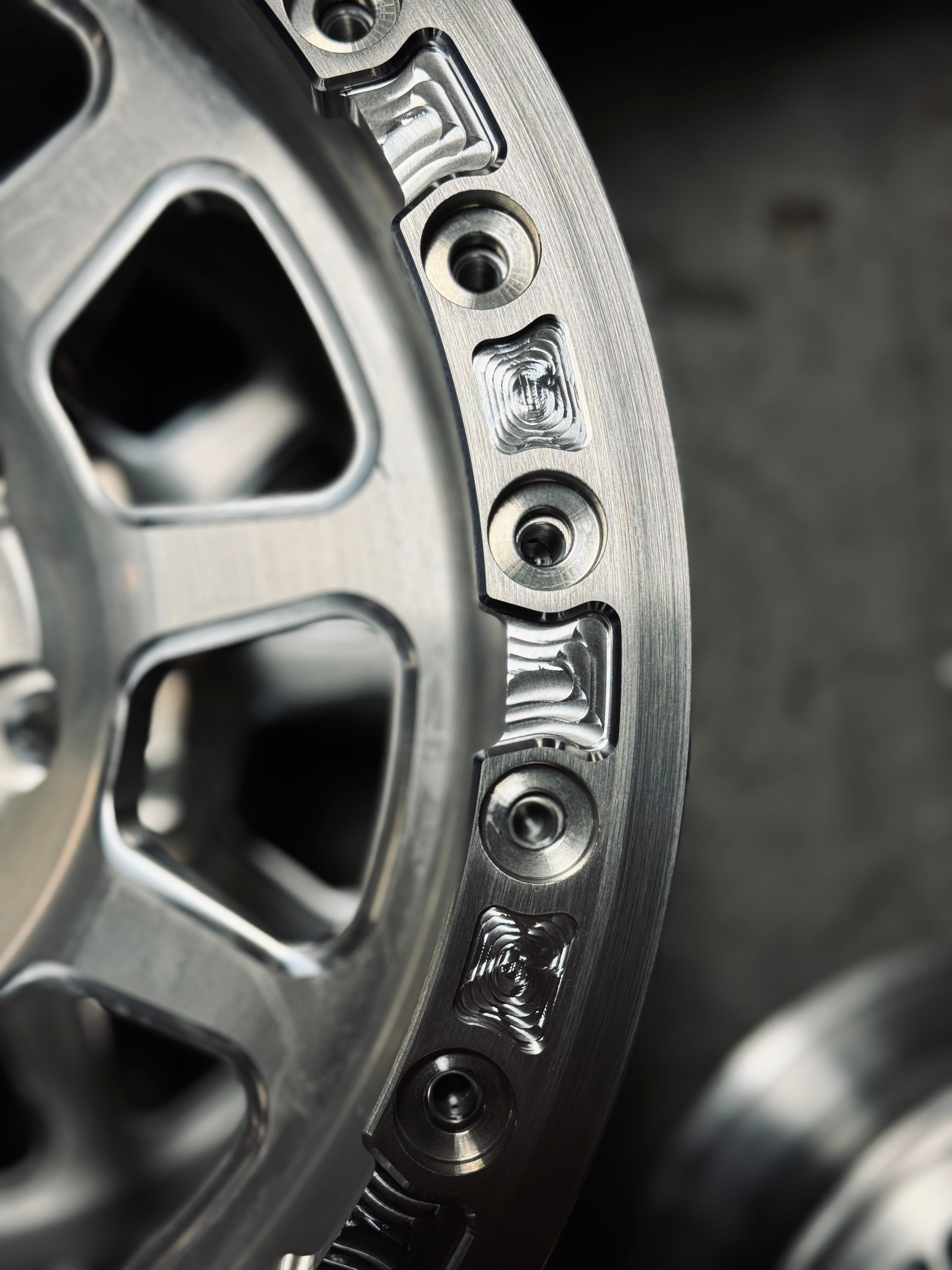 Close-up of an aluminum beadlock ring showcasing its detailed design and secure fastening points for offroad wheels.