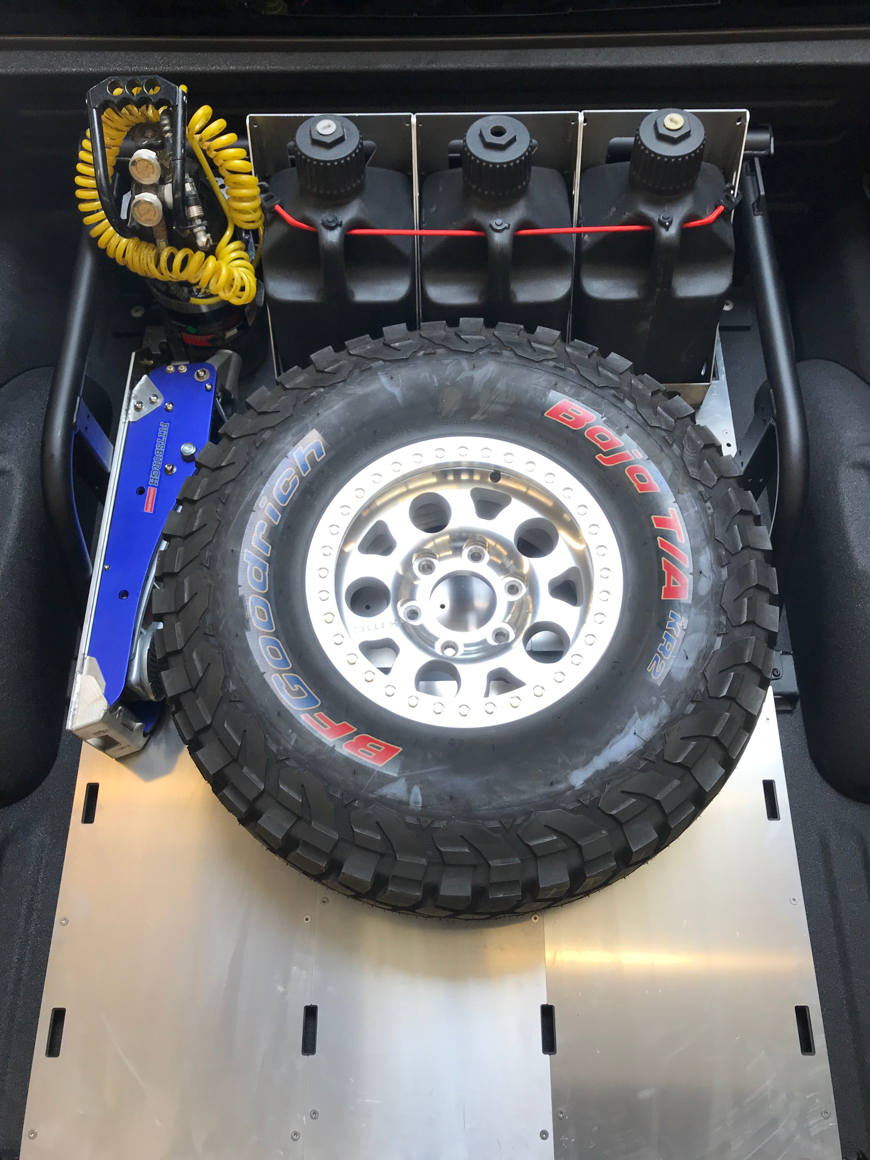 Modular bed organizer for 2017-2024 Ford Raptor and F150, featuring a mounted spare tire and storage for tools and equipment.