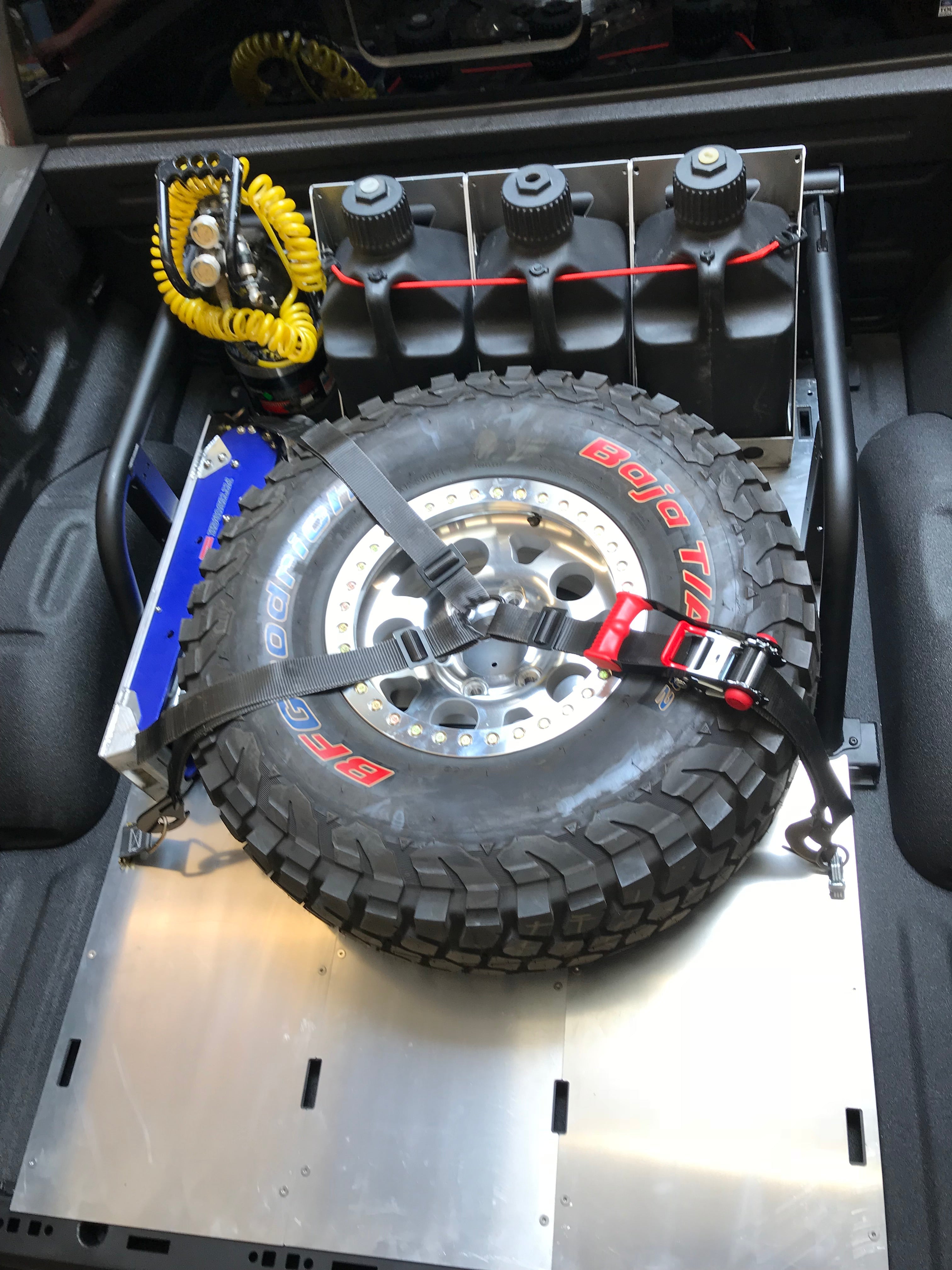 Modular bed organizer for 2017-2024 Ford Raptor and F150, featuring a secure tire mount and storage for tools and gear.