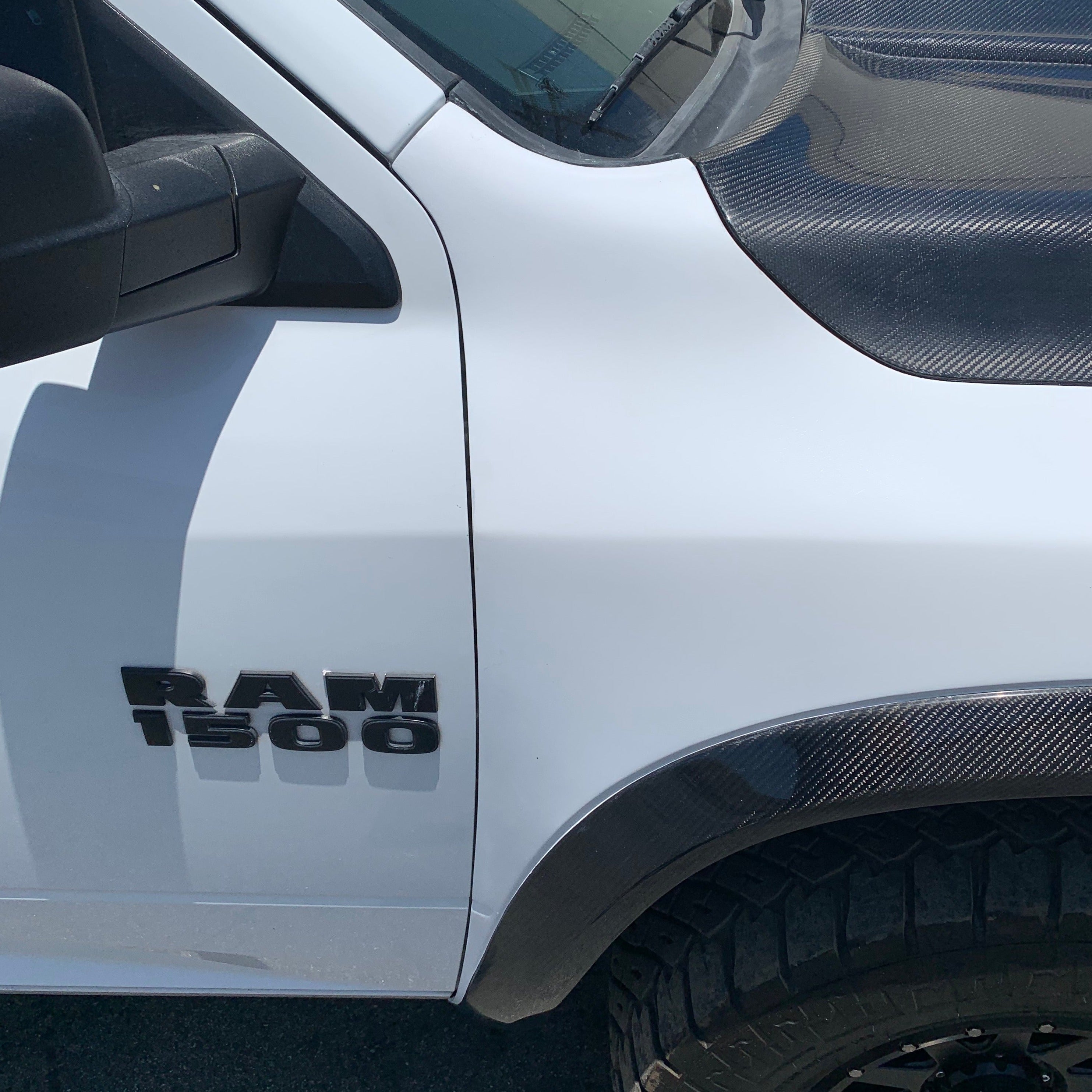 2009-2018 Dodge Ram TRX Kit displayed on a white truck, highlighting the RAM 1500 badge and textured hood.