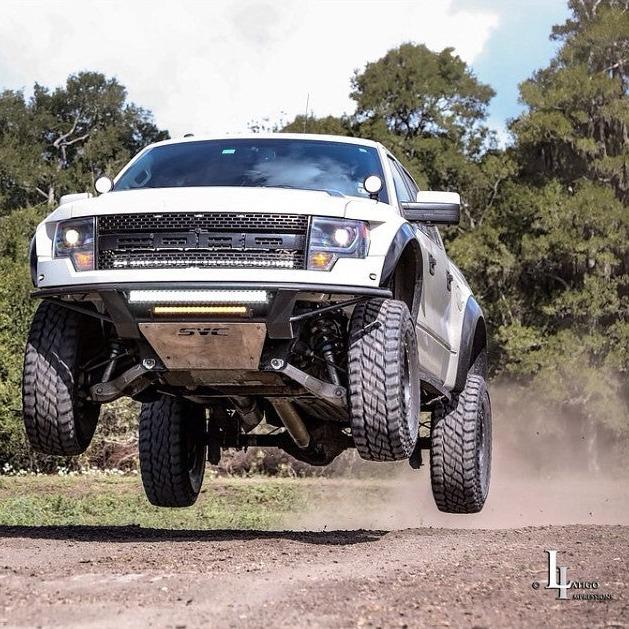 2010-2016 Ford Raptor fenders showcased on a truck jumping off-road, highlighting durability and performance.