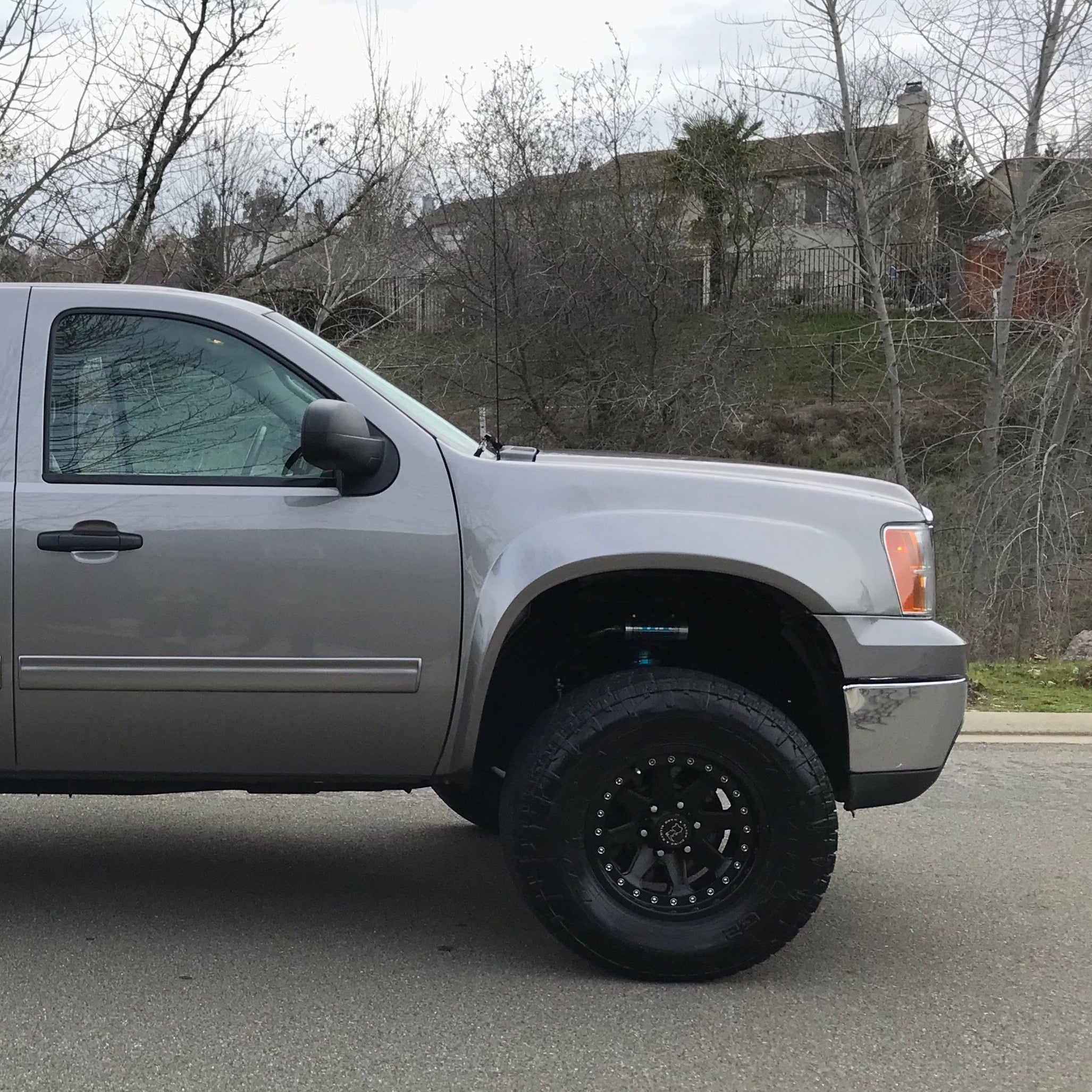 2007-2013 GMC Sierra fenders installed on a lifted truck, showcasing enhanced off-road capabilities and style.