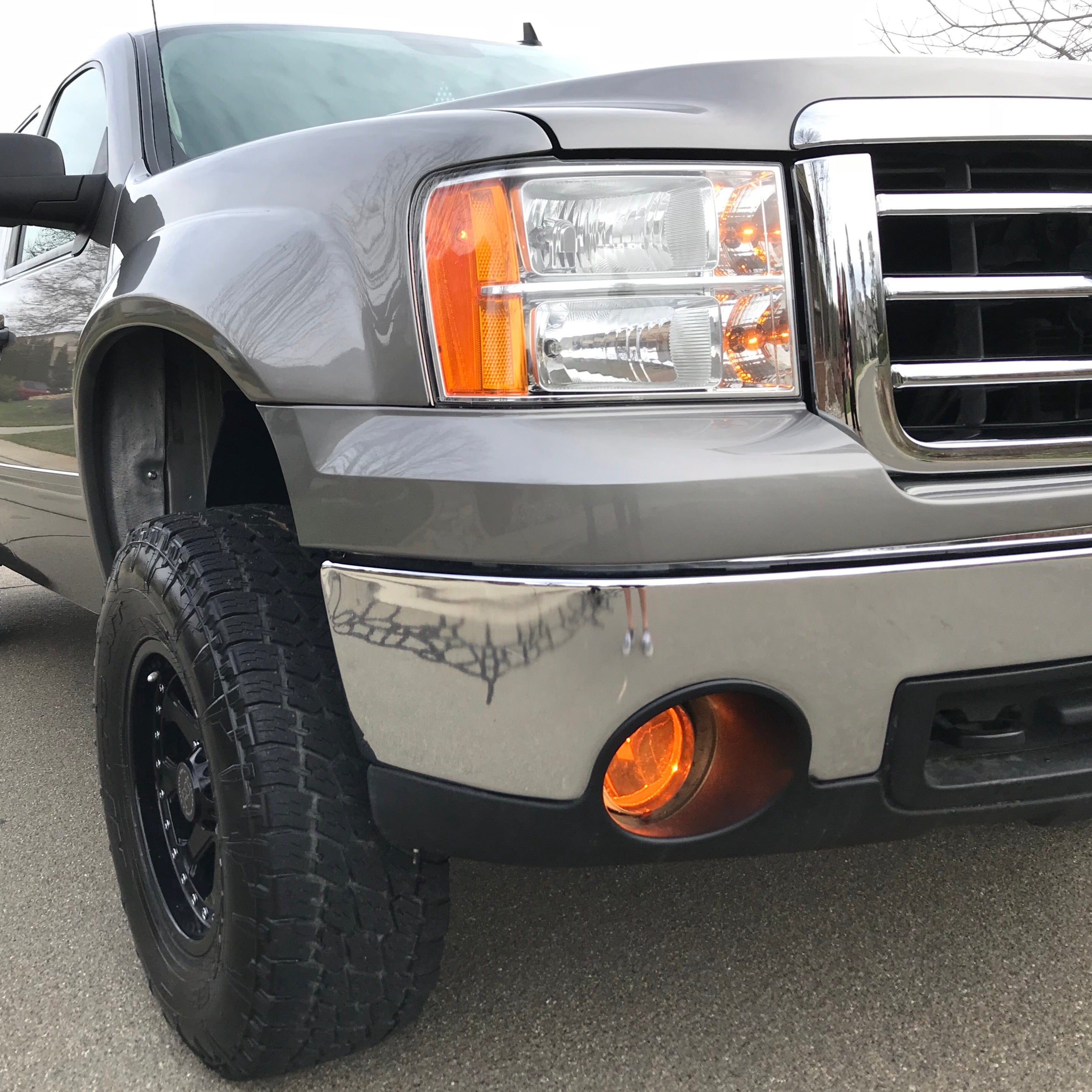 2007-2013 GMC Sierra fenders showcasing a truck with a chrome bumper and off-road tires, emphasizing rugged design.