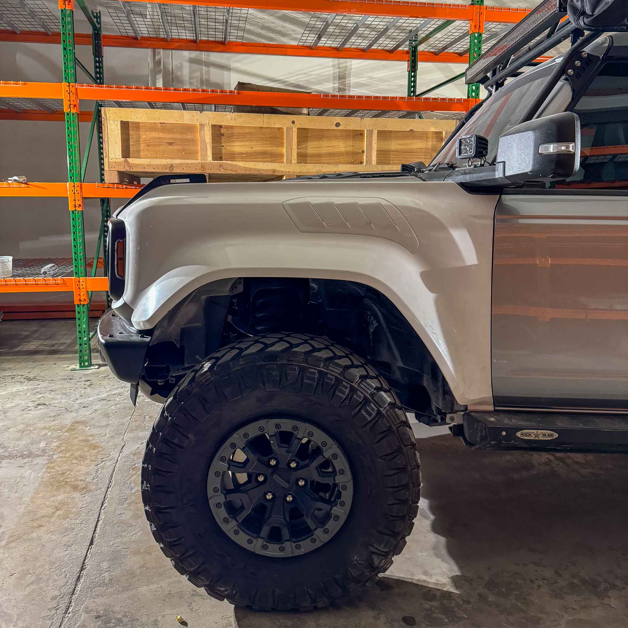 2022-2025 Ford Bronco Raptor fenders showcasing rugged design and fitment on a lifted vehicle in a storage area.
