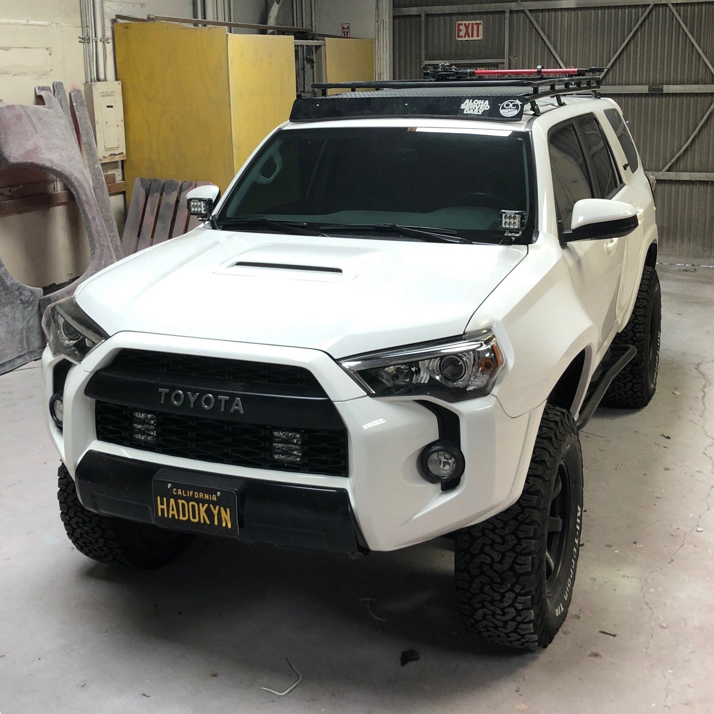 2010-2022 Toyota 4-Runner with custom fenders, offroad tires, and roof rack in a workshop setting.