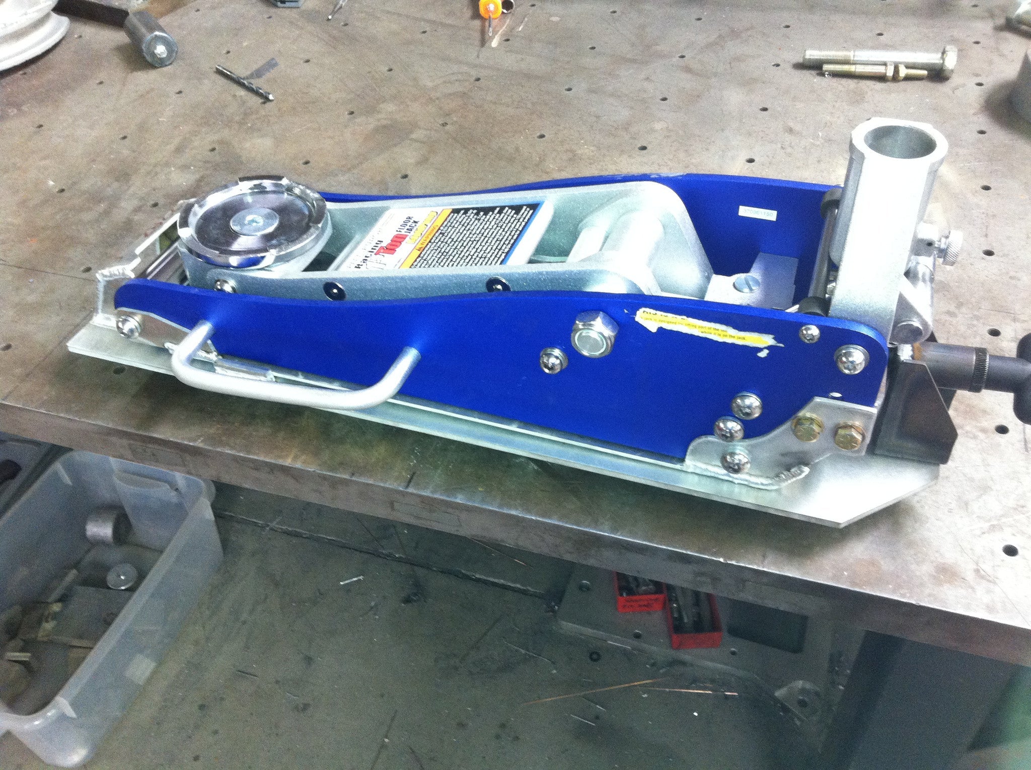 2.5 Ton Quick Release Jack Kit on a workbench, showcasing its durable design and easy-to-use features for vehicle maintenance.