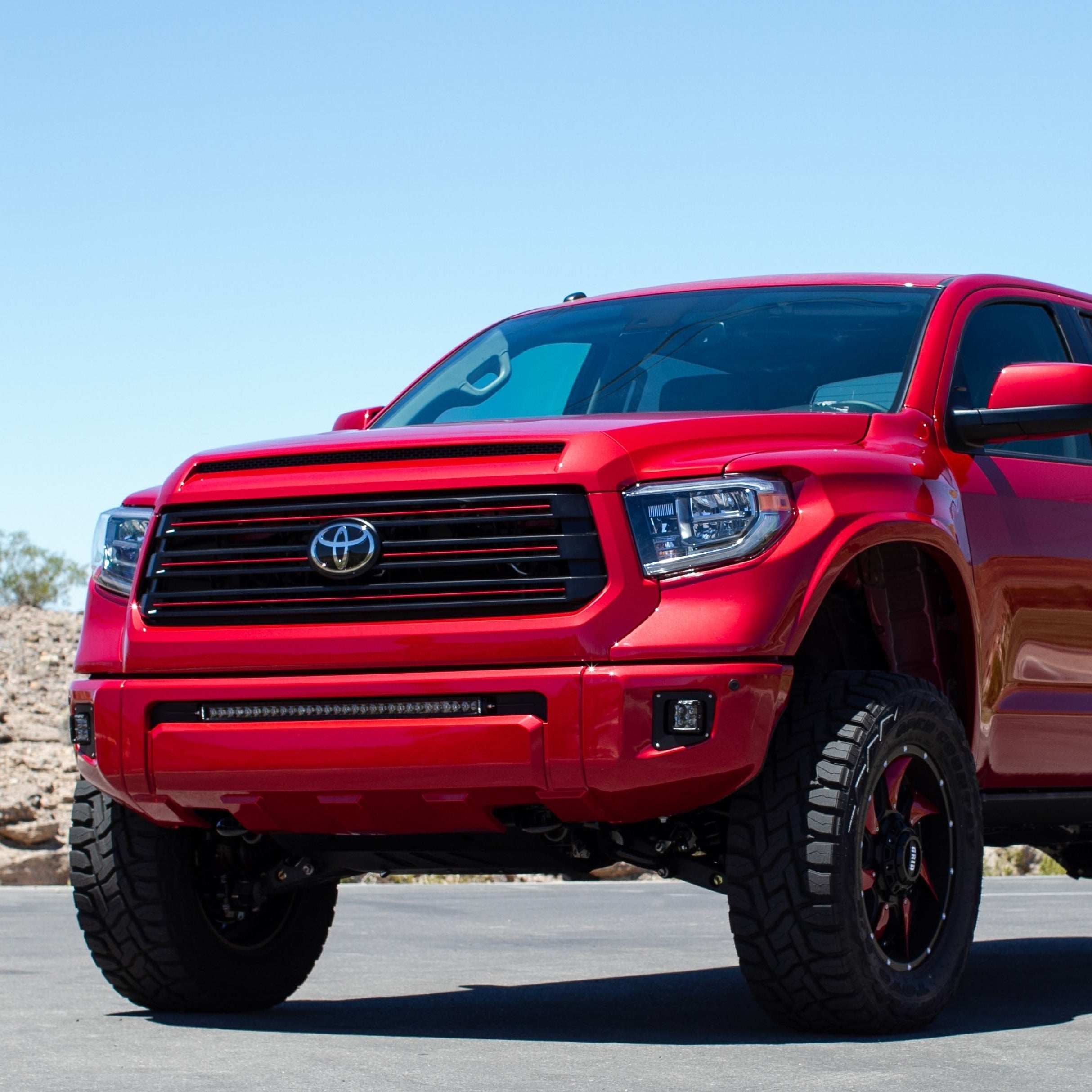 2014-2021 Toyota Tundra fenders showcasing a lifted red truck with rugged tires and a bold front grille.