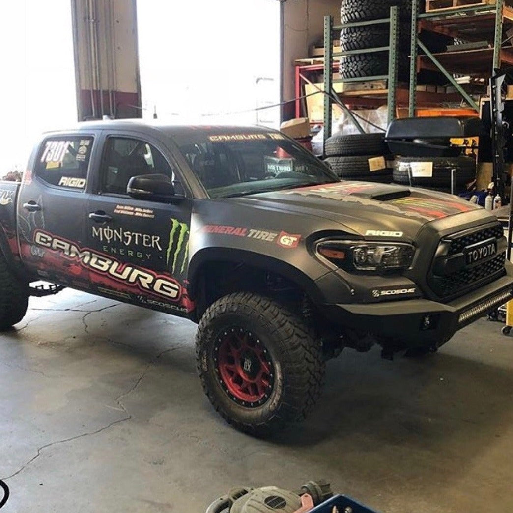 2016-2023 Toyota Tacoma fenders displayed on a modified truck in a garage, showcasing offroad capabilities and rugged design.