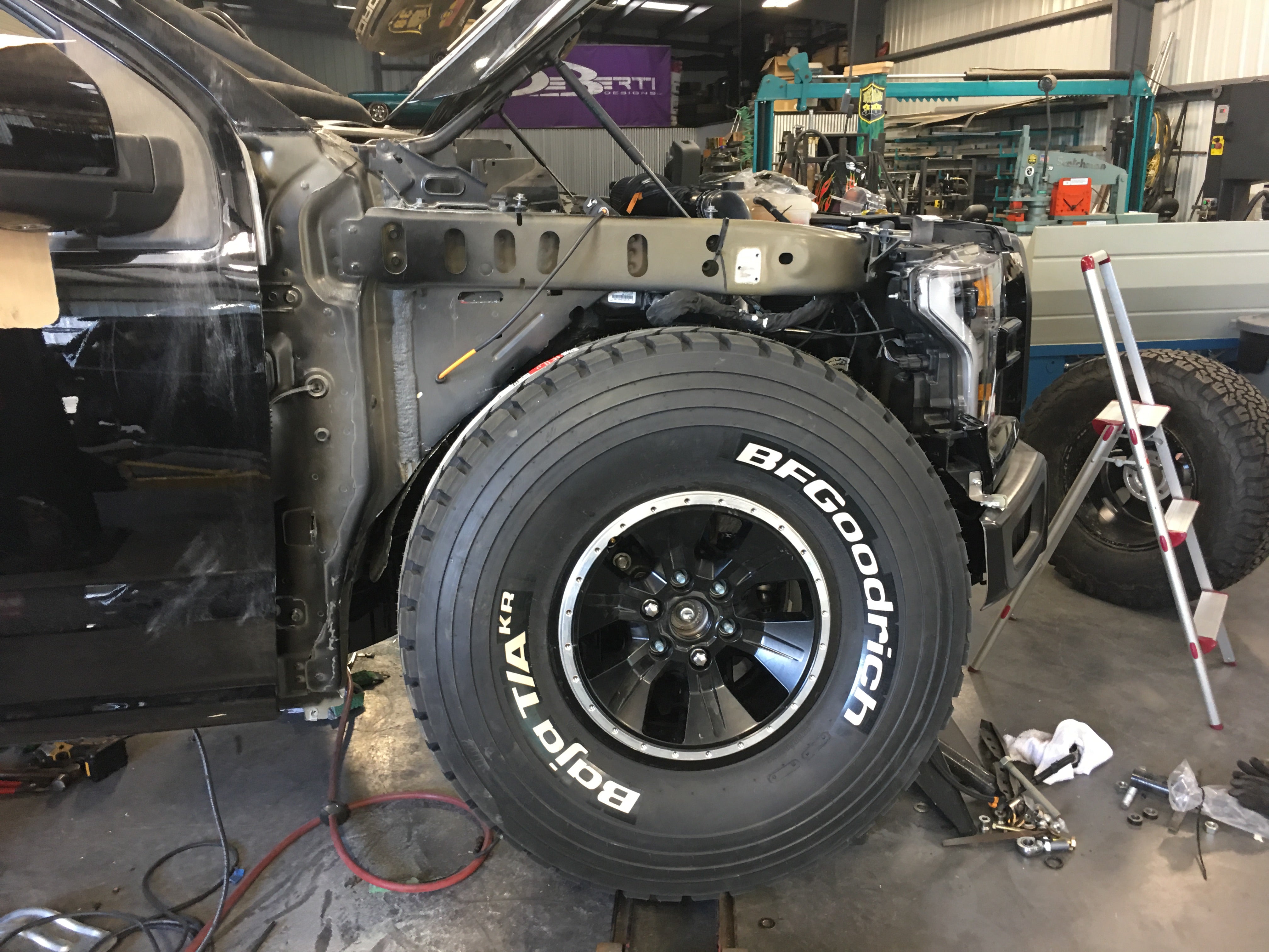 2017 Up Raptor Long Travel Front Suspension Kit installed on a truck, showcasing the suspension components and large tire.