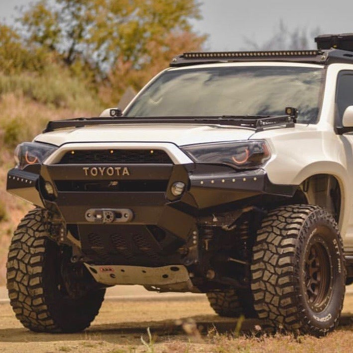 2010-2024 Toyota 4-Runner with rugged fenders, enhanced off-road tires, and a bold front grille in a natural setting.