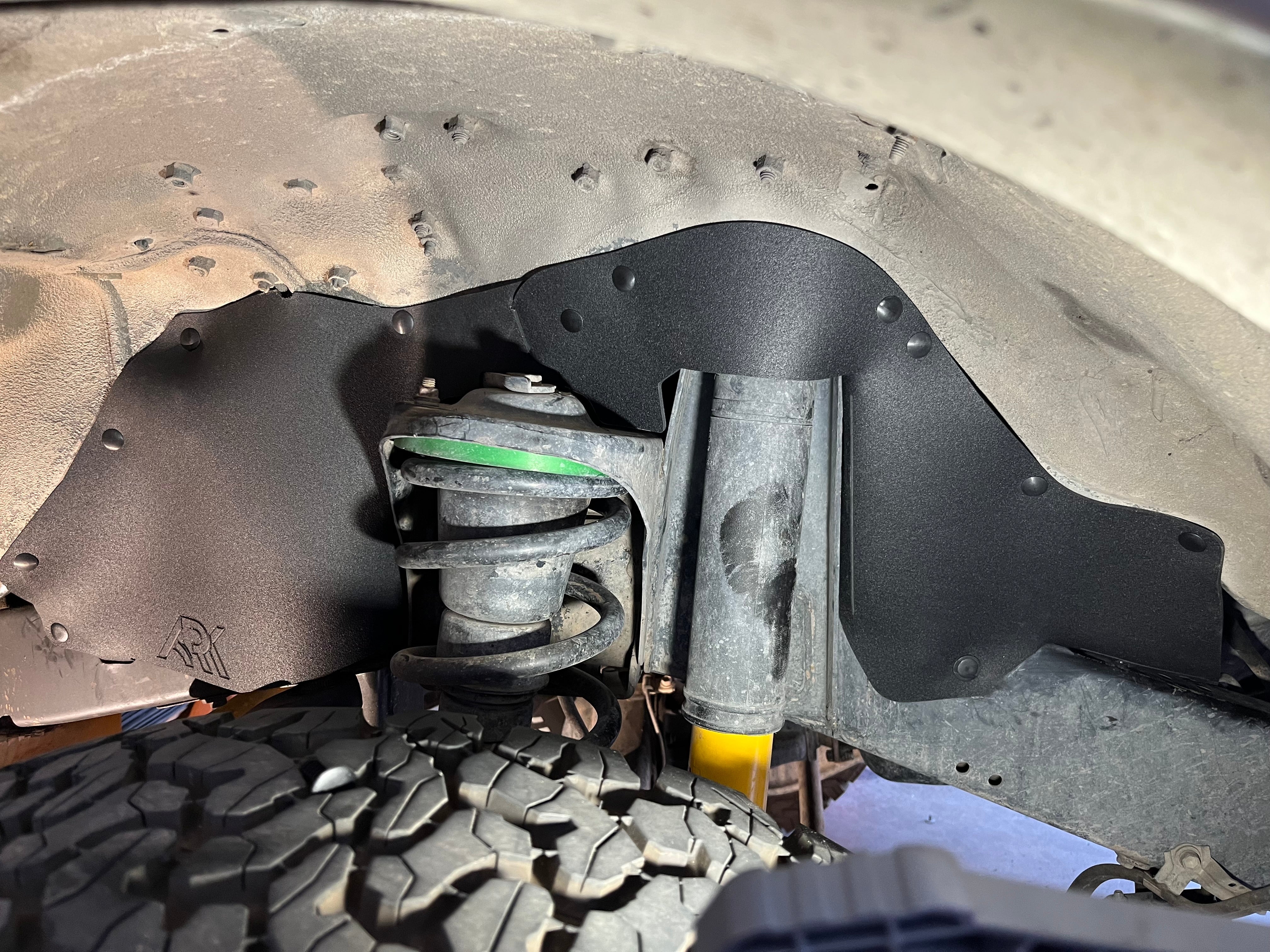 Splash guards installed on a 1993-1997 Toyota Land Cruiser FZJ80, protecting suspension components from debris.