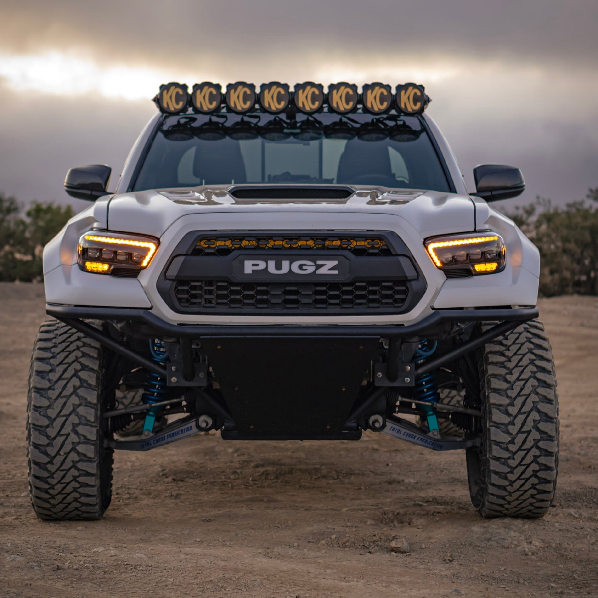 Toyota Tacoma with aftermarket fenders, showcasing offroad features and enhanced lighting for rugged terrain.