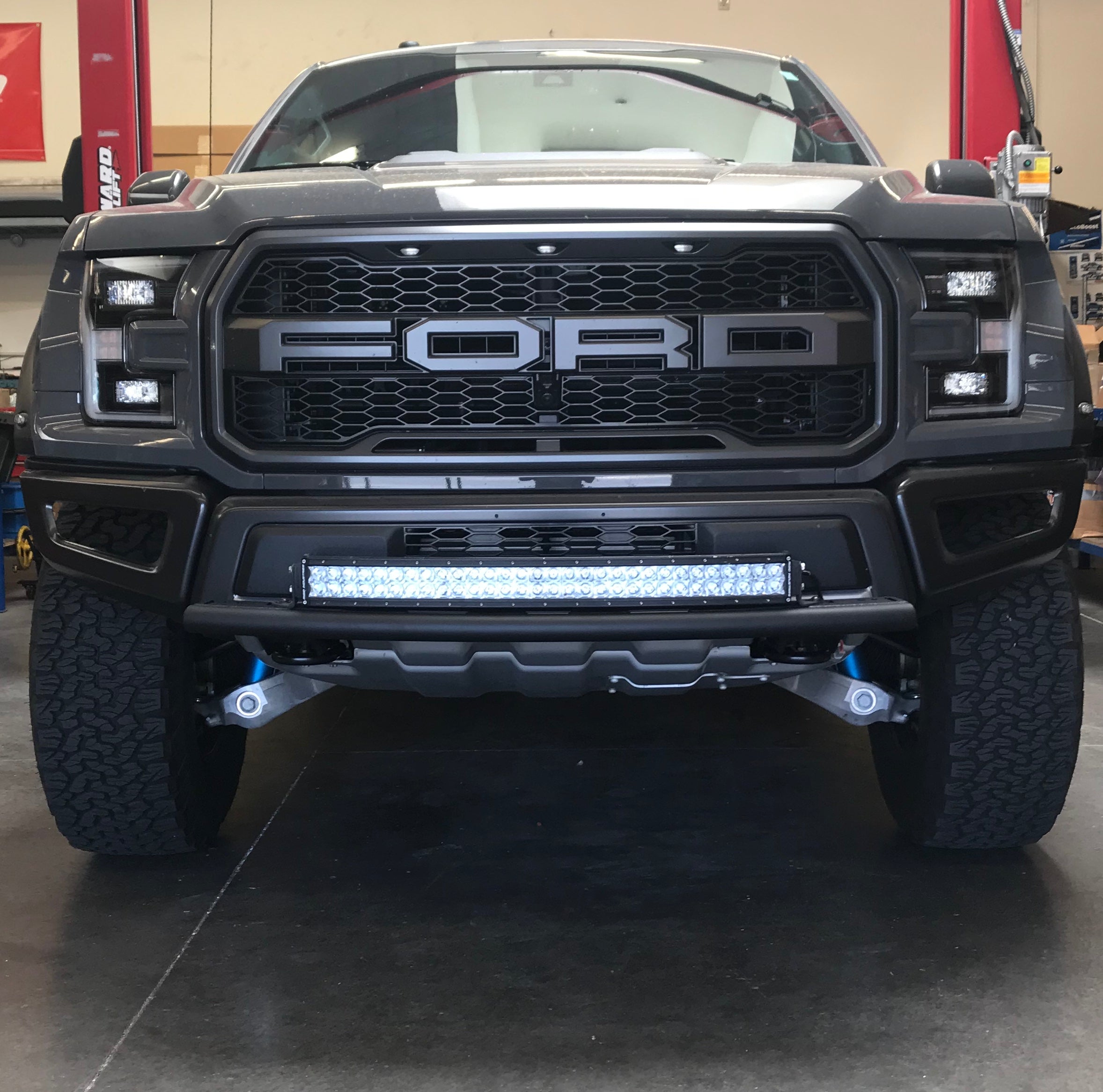 Single tube light mount for 2015+ F150 and 2017+ Raptor, installed on a stock bumper, showcasing a rugged front view.